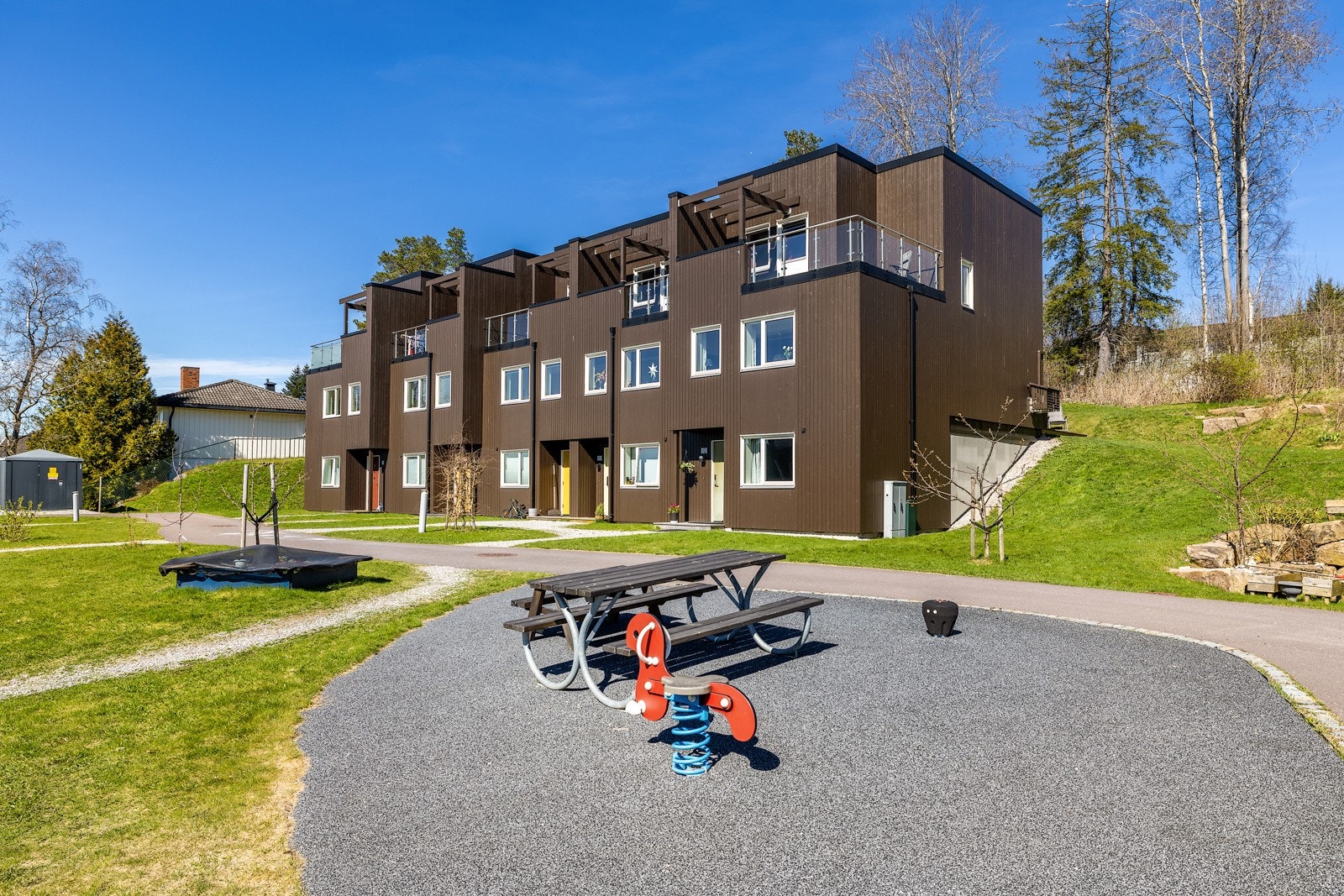 Velkommen til Brudeberget 12. Felles uteplass med lekeapparater og piknikbord rett utenfor døra. Foto: Digit Media Galleribilde