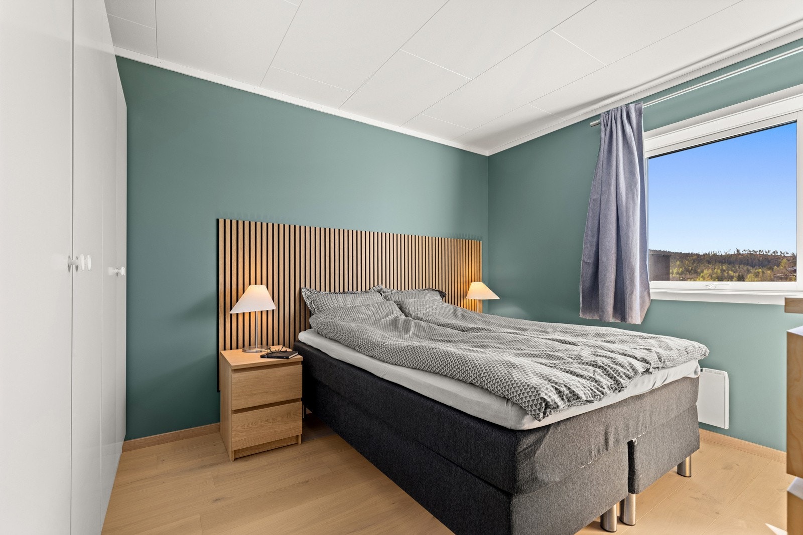 Hovedsoverommet har plass til stor dobbeltseng, og er dekorert med grønn fondvegg og panel i tremønster. Galleribilde