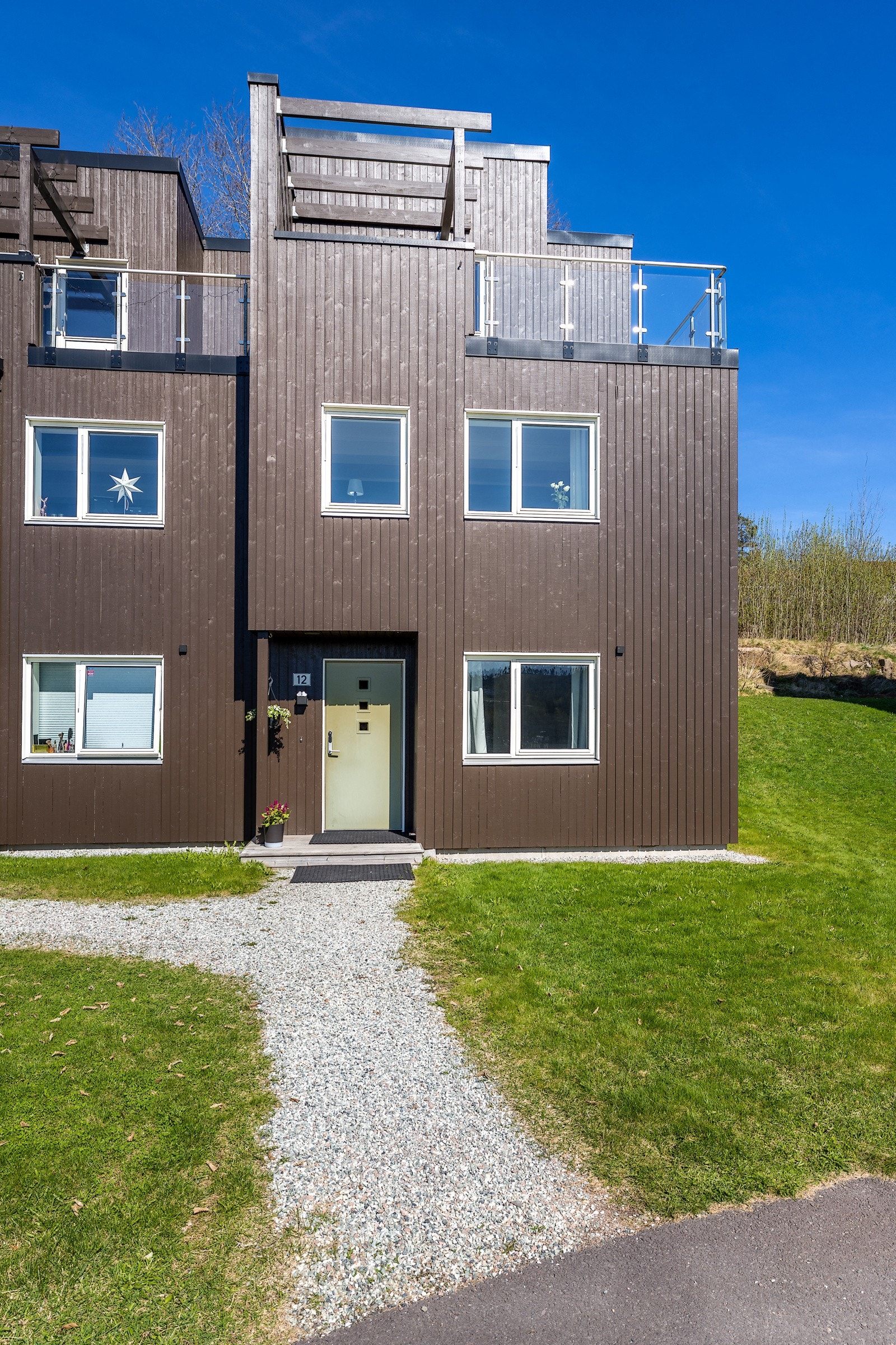 Moderne arkitektur i tre etasjer, med takterrasse på toppen og store vindusflater. Galleribilde