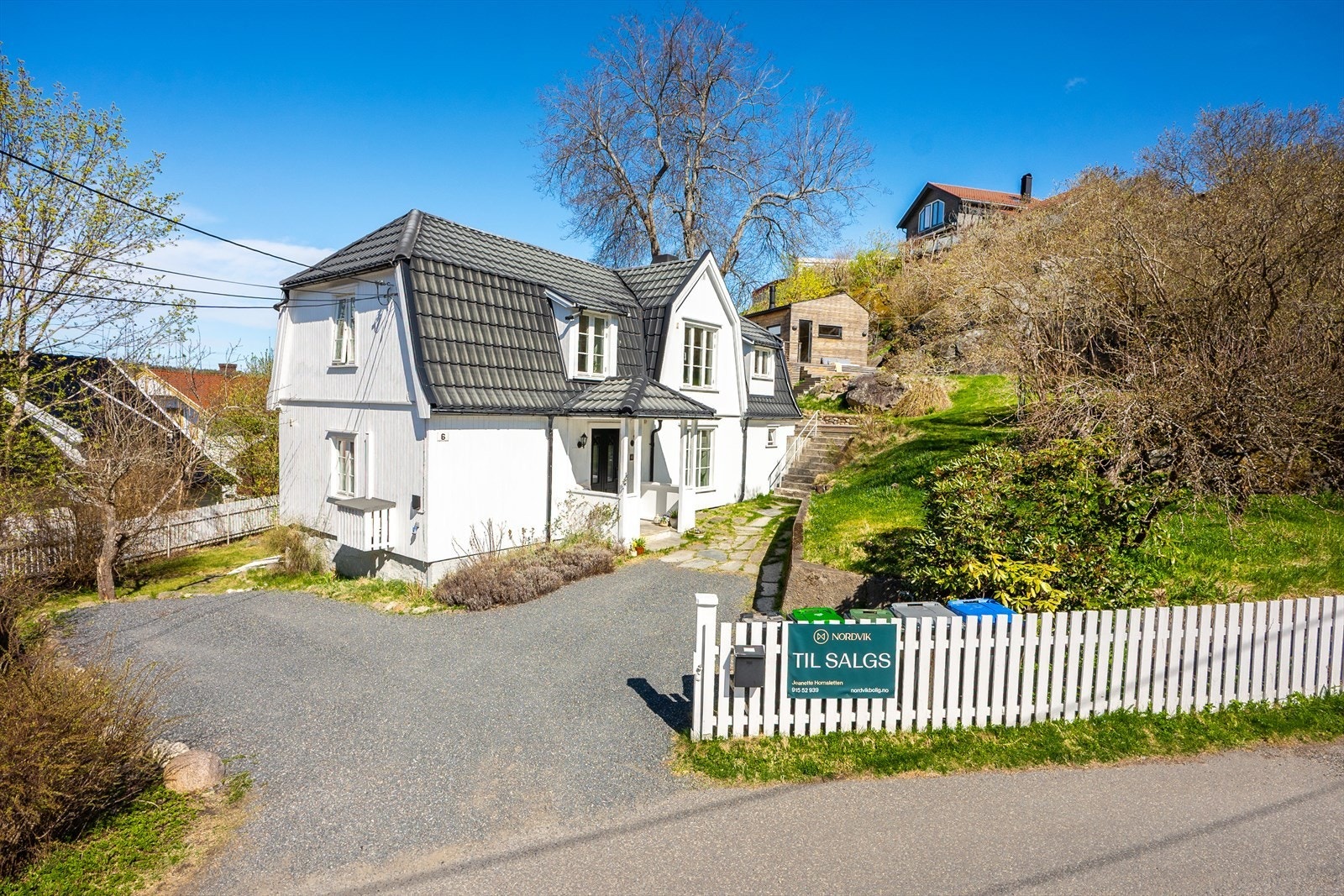 Innbydende inngangsparti med overbygget adkomst som gir en hyggelig velkomst til boligen. Det er montert elbil lader i tilknytning til biloppstillingsplasser. Galleribilde