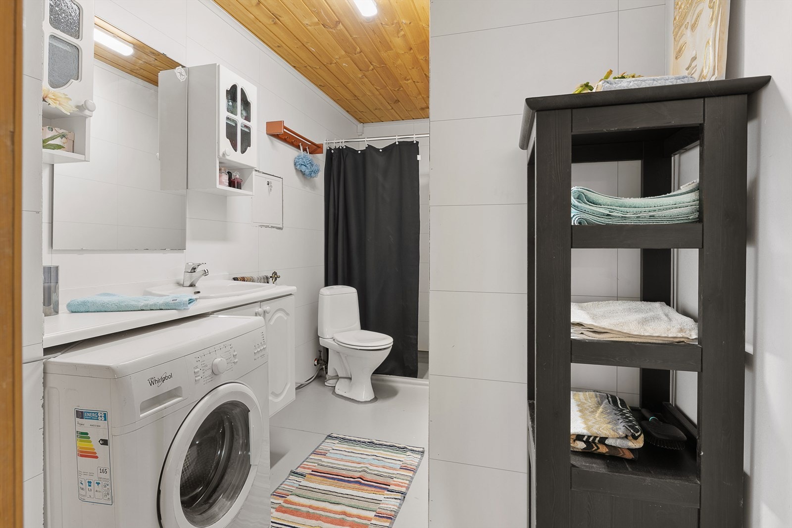 Bad med WC, servant med underskap, dusjhjørne og opplegg for vaskemaskin. Galleribilde