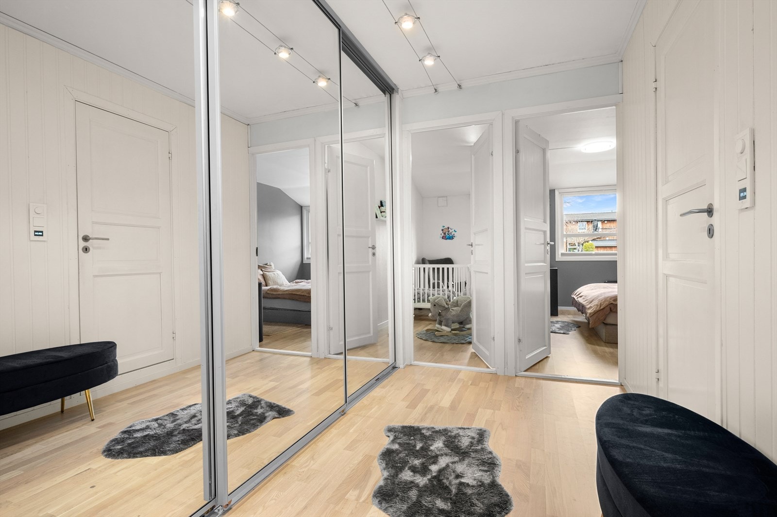 Fra kjøkkenet er det en romslig gang mellom bad og soverom. Her er det montert en praktisk skyvedørsgarderobe for ytterligere lagringsplass. Galleribilde