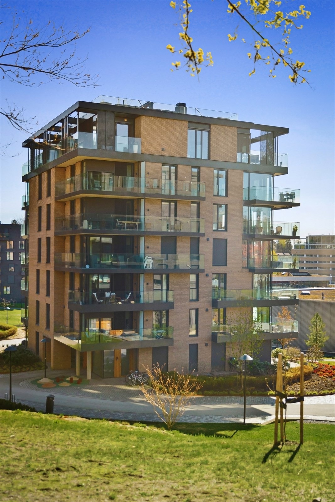 Store, fine utearealer pent opparbeidet med fine gangstier, lekeplass, beplantning, plen og sykkelparkering. Galleribilde