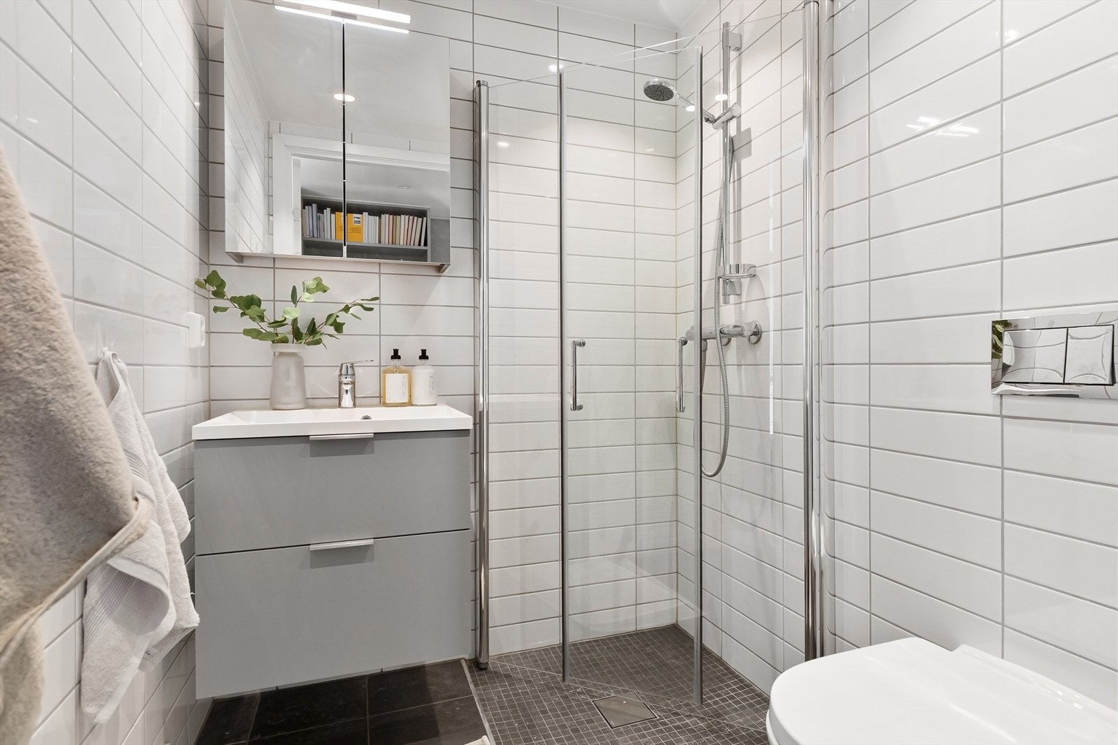 Bad 2 inn fra oppholdsrom. Utstyrt med dusj, innsvingbare glassdører, servantinnredning og veggmontert toalett. Galleribilde