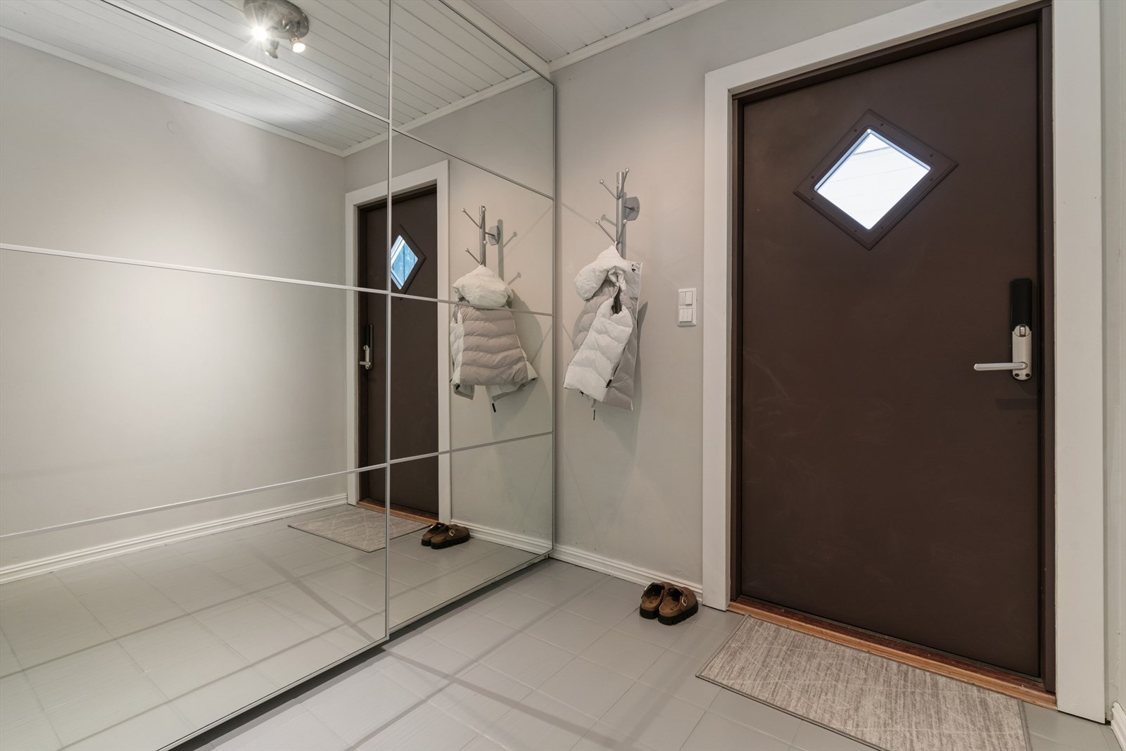 Entréen har varme i gulvet og god oppbevaringsplass i en romslig skyvedørsgarderobe med speilfronter. Galleribilde