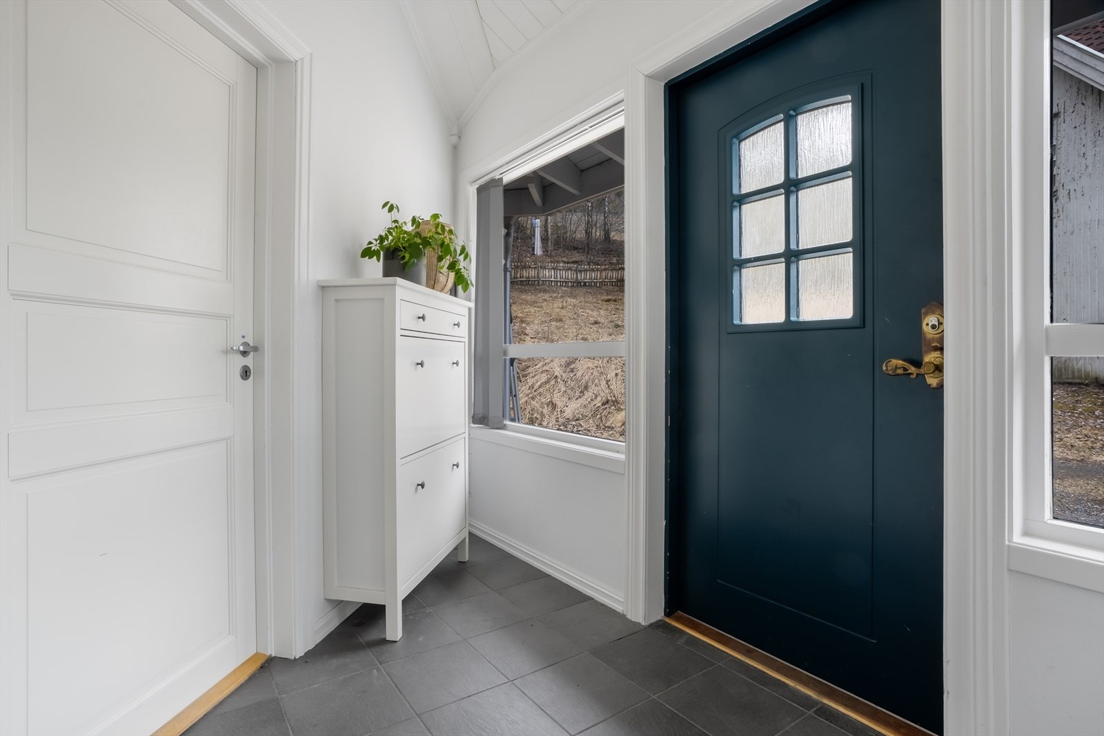 Entréen har et praktisk, flislagt gulv med gulvvarme. Varmekabler er også lagt i plattingen utenfor inngangsdøren. Galleribilde