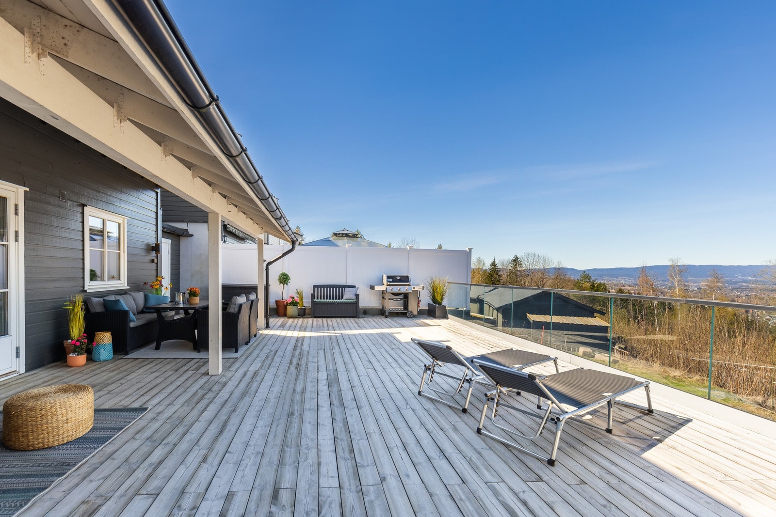 Romslig terrasse med gode solforhold, flere sitteplasser og grillområde. Nydelig utsikt over eikerbygdene. Galleribilde