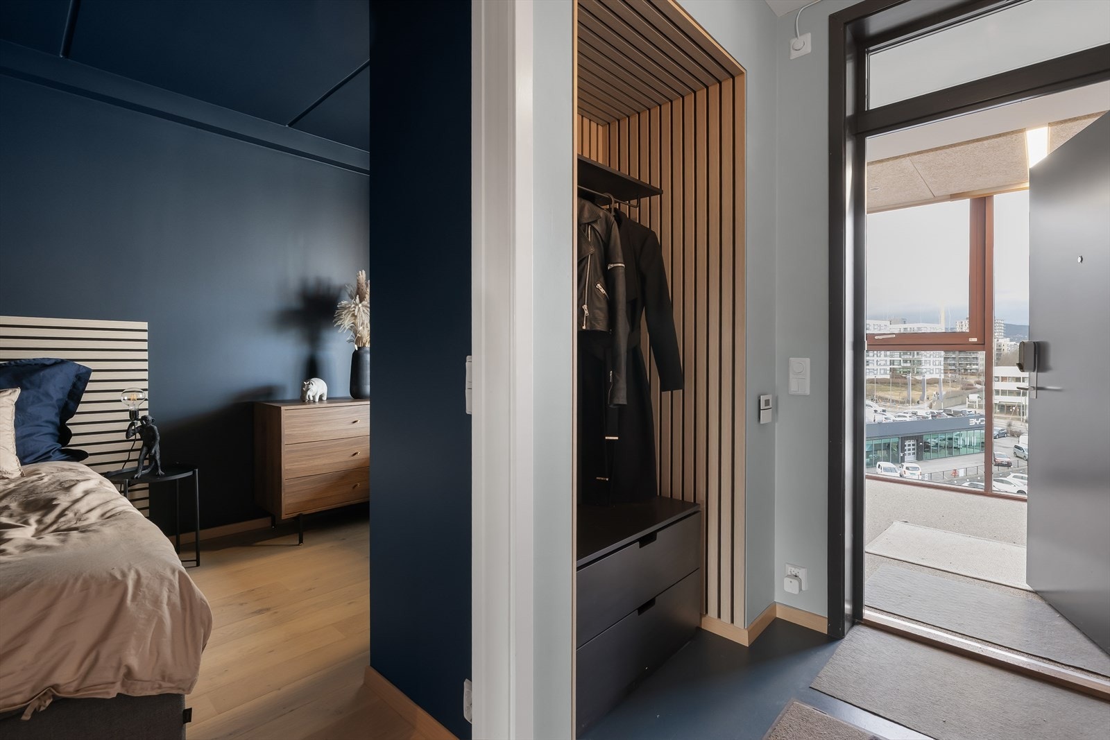 Romslig entré med belegg på gulv, gulvvarme, malte veggflater og downlights i himling Galleribilde