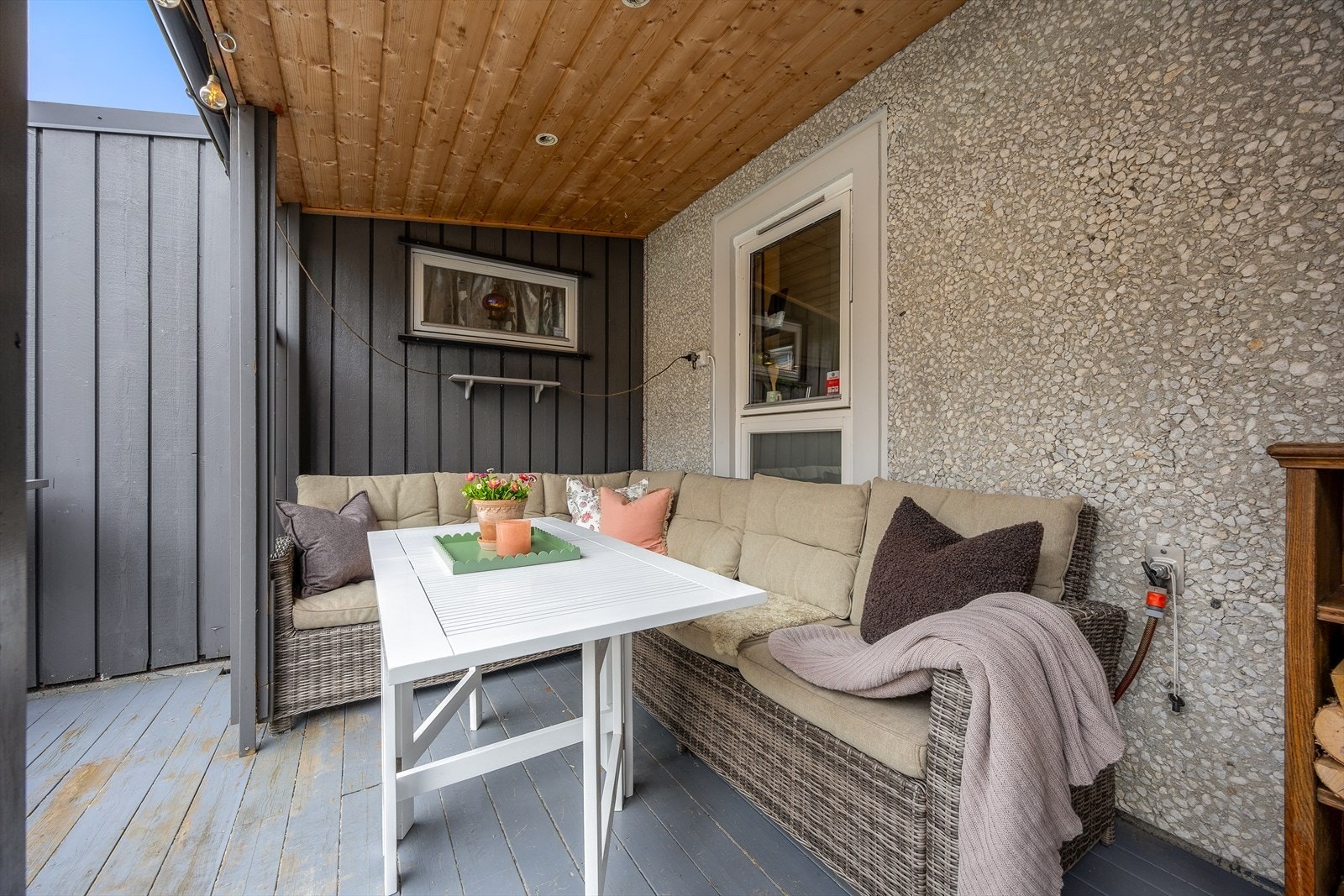 Den overbygde delen av terrassen gir en lun krok for en utendørs sofagruppe. Galleribilde
