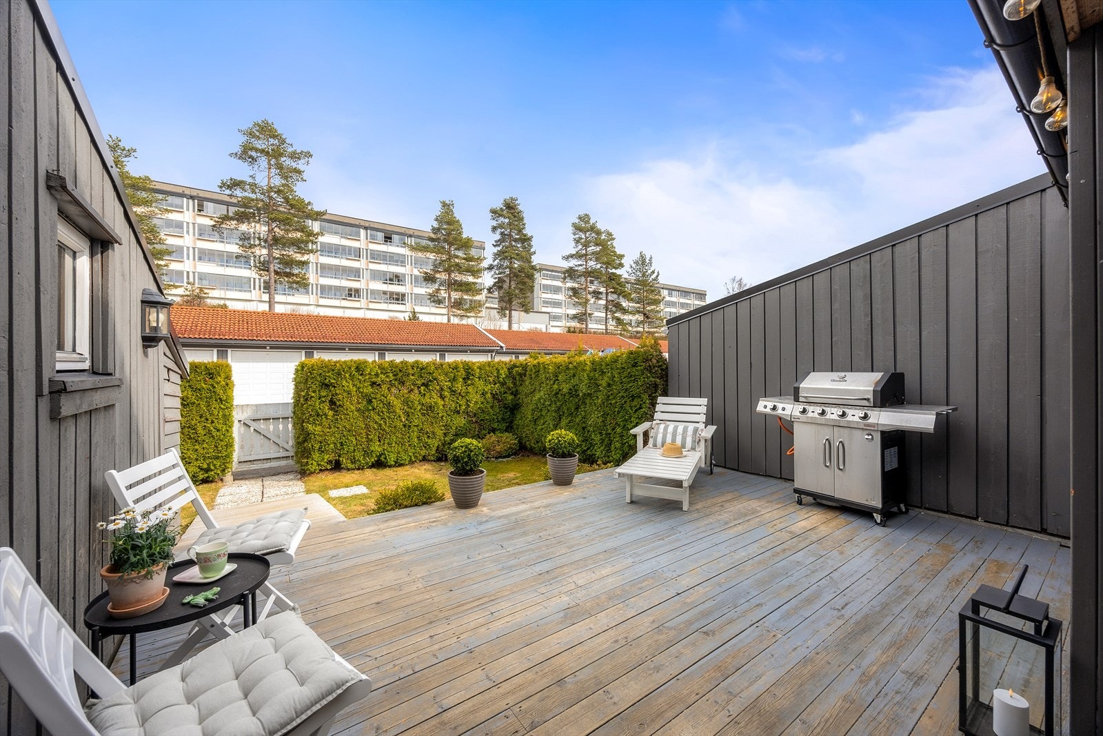 Boligen har to terrasser på til sammen 49 m². Her ved inngangspartiet er det en usjenert uteplass på 28 m², skjermet av hekk. Galleribilde