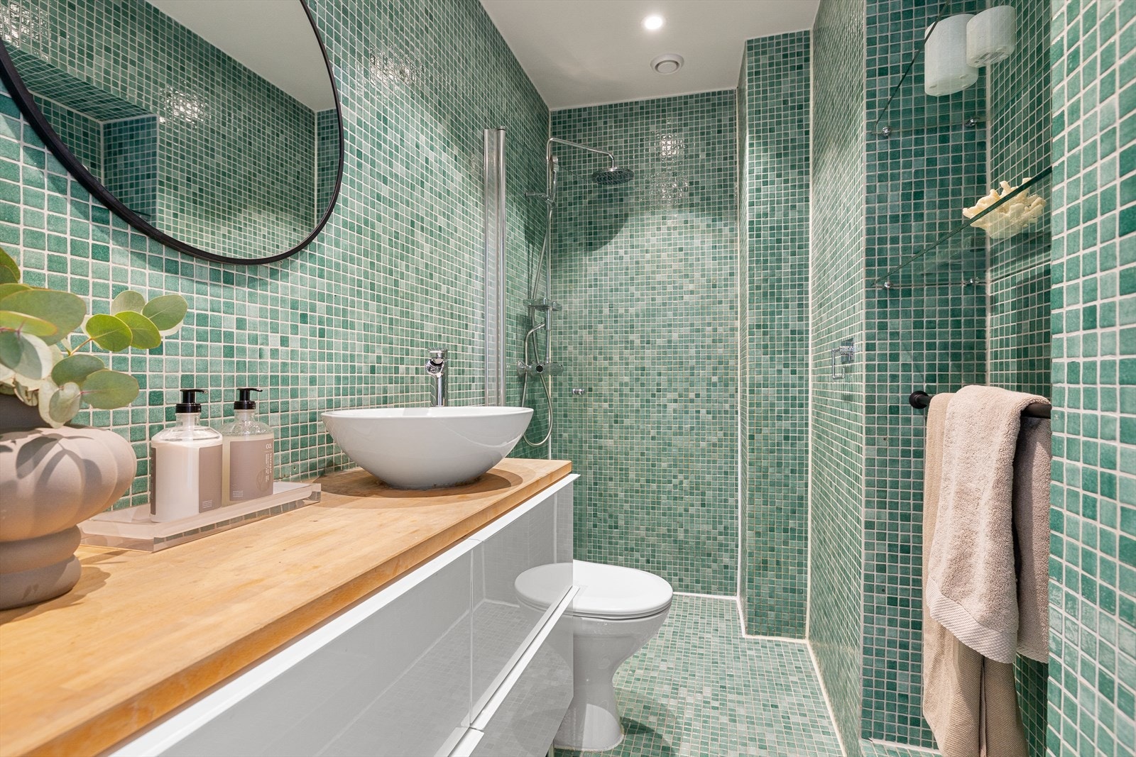 Badet er av eldre dato og ble oppgradert i regi av borettslaget i 2002/2003. Det har flislagt gulv med gulvvarme. Badet er innredet med WC, dusjplass med vegg og servant med ettgreps blandebatteri samt tilhørende innredning. Galleribilde