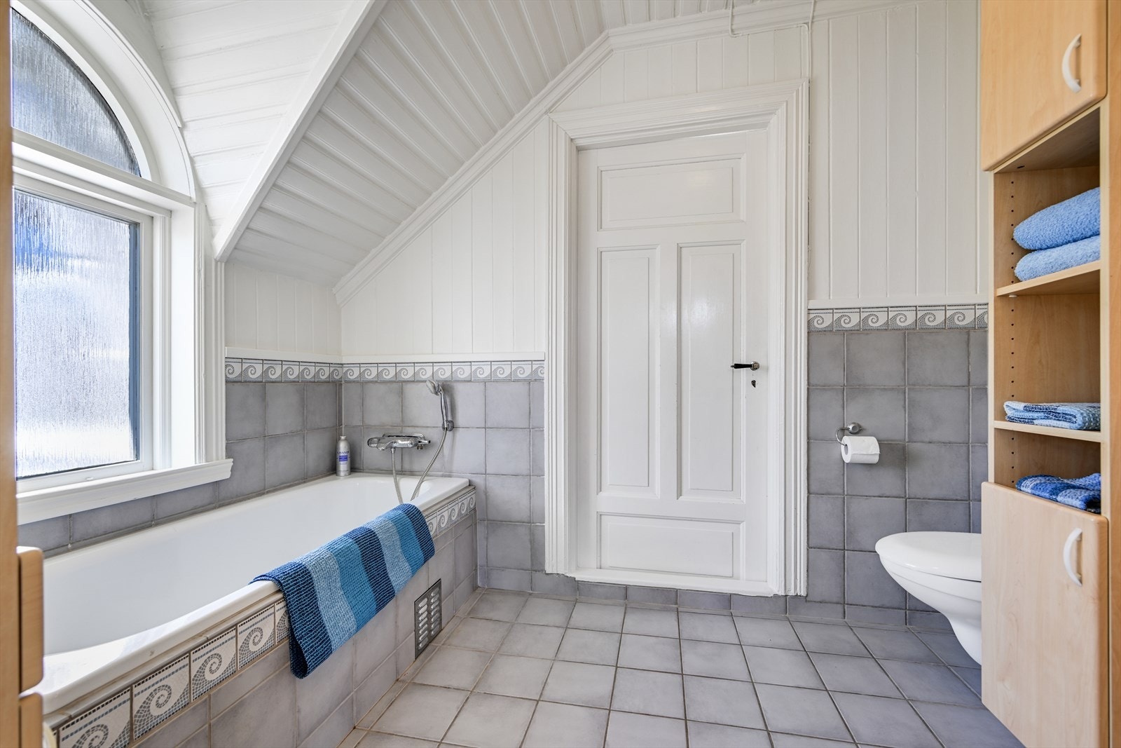 Fliselagt bad/wc i 2. etasje, med badekar og vegghengt toalett. Galleribilde