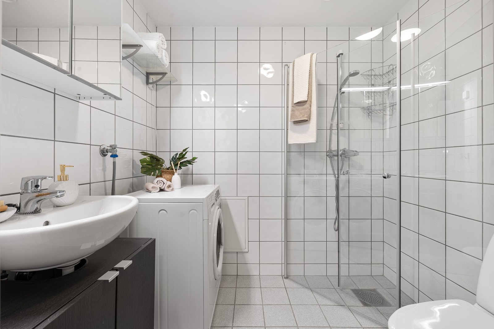 Det lyse badet med flis på gulv og vegger oppleves innbydende og holdes varmt ved bruk av vannbåren varme i gulv. Galleribilde