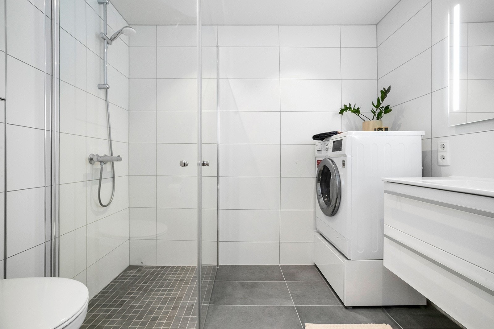 Badet er stilrent og moderne med flislagte overflater Galleribilde
