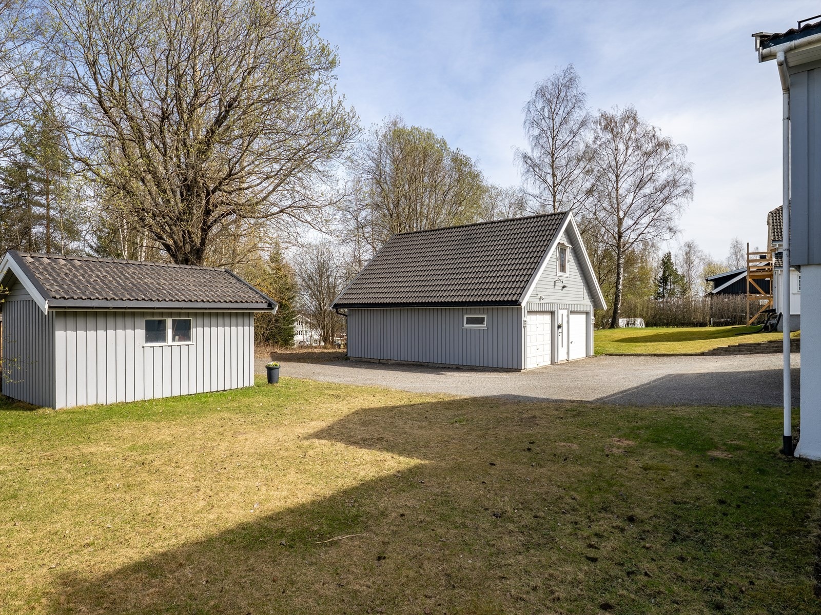 Eiendommen inkluderer en dobbelgarasje på 88 m² med lagringsloft, samt et separat uthus på 13 m² for ekstra lagringsmuligheter. Galleribilde