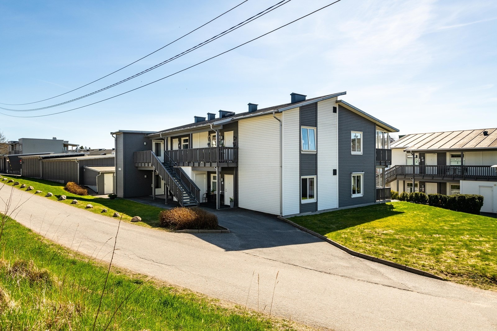 Det er ifølge selger lov for denne boligen å benytte seg av asfaltert plass utenfor til parkeringsplass. Ellers har boligen også carport i rekke som du ser til venstre på bildet her. Utvendig bod ved carport og under utenfor inngangen/ved siden av trappen Galleribilde