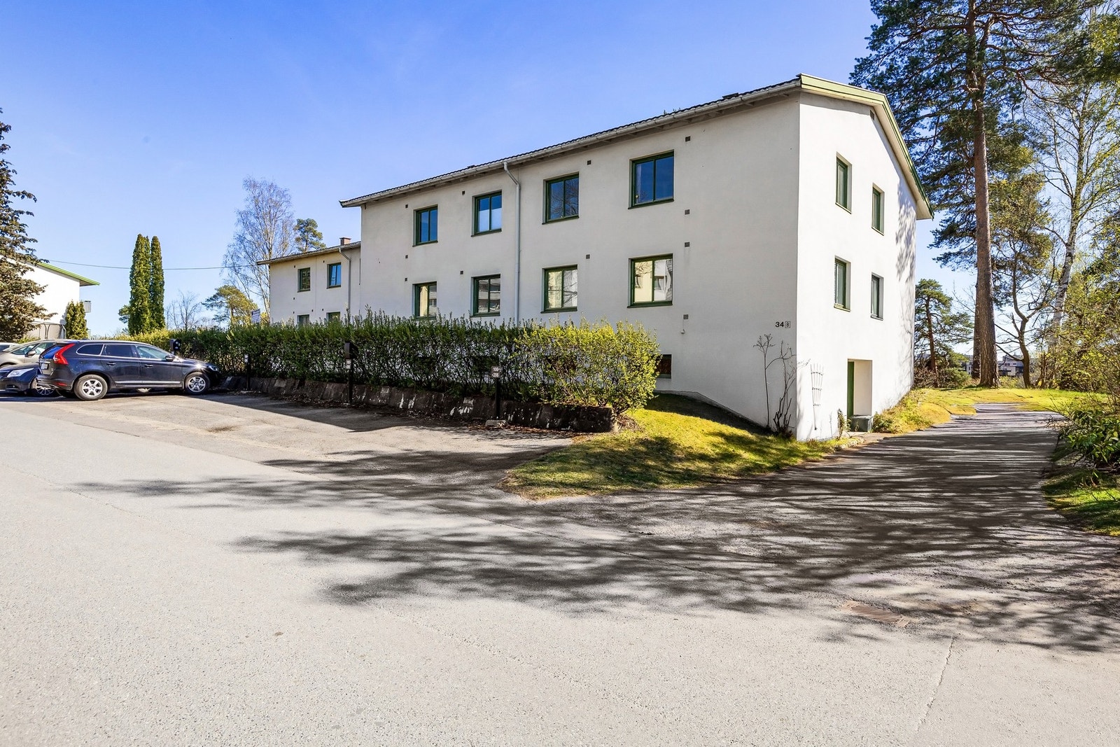 Et veldrevet aksjelag i rolige omgivelser. Parkeringsplass med lader foran gården Galleribilde