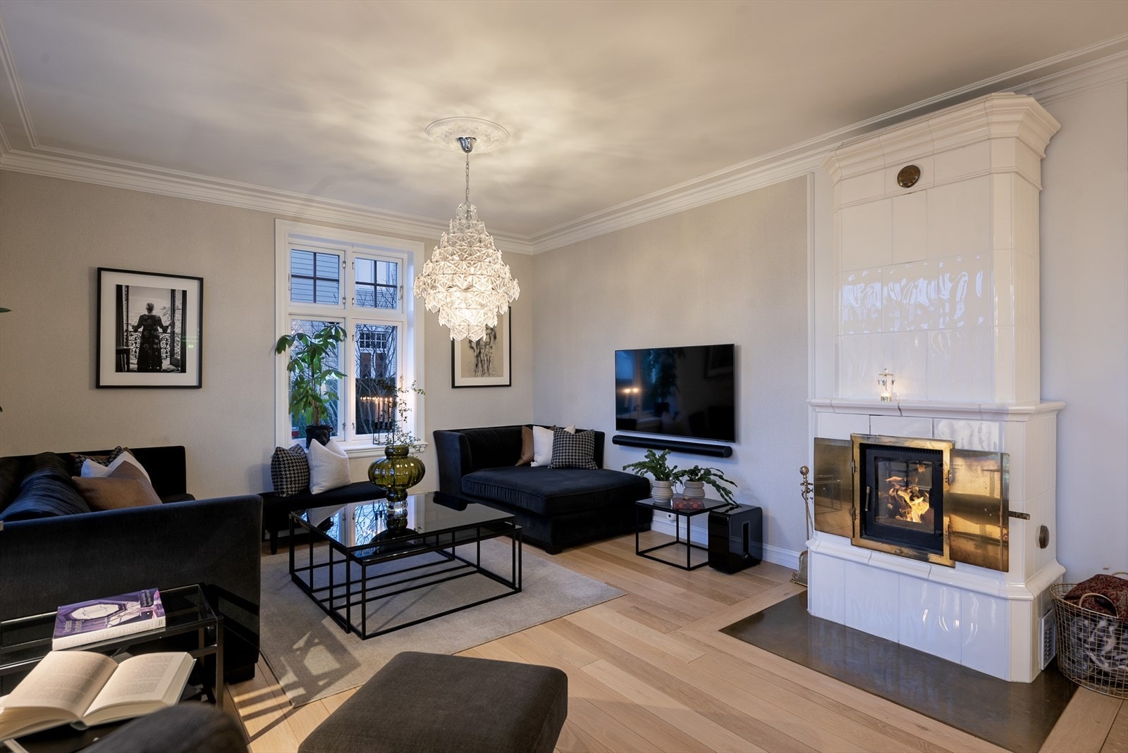 Kakkelovn/peis med glassdør med synlig ild som gir varme og stemning. Varmt, elegant og tidløst. Galleribilde
