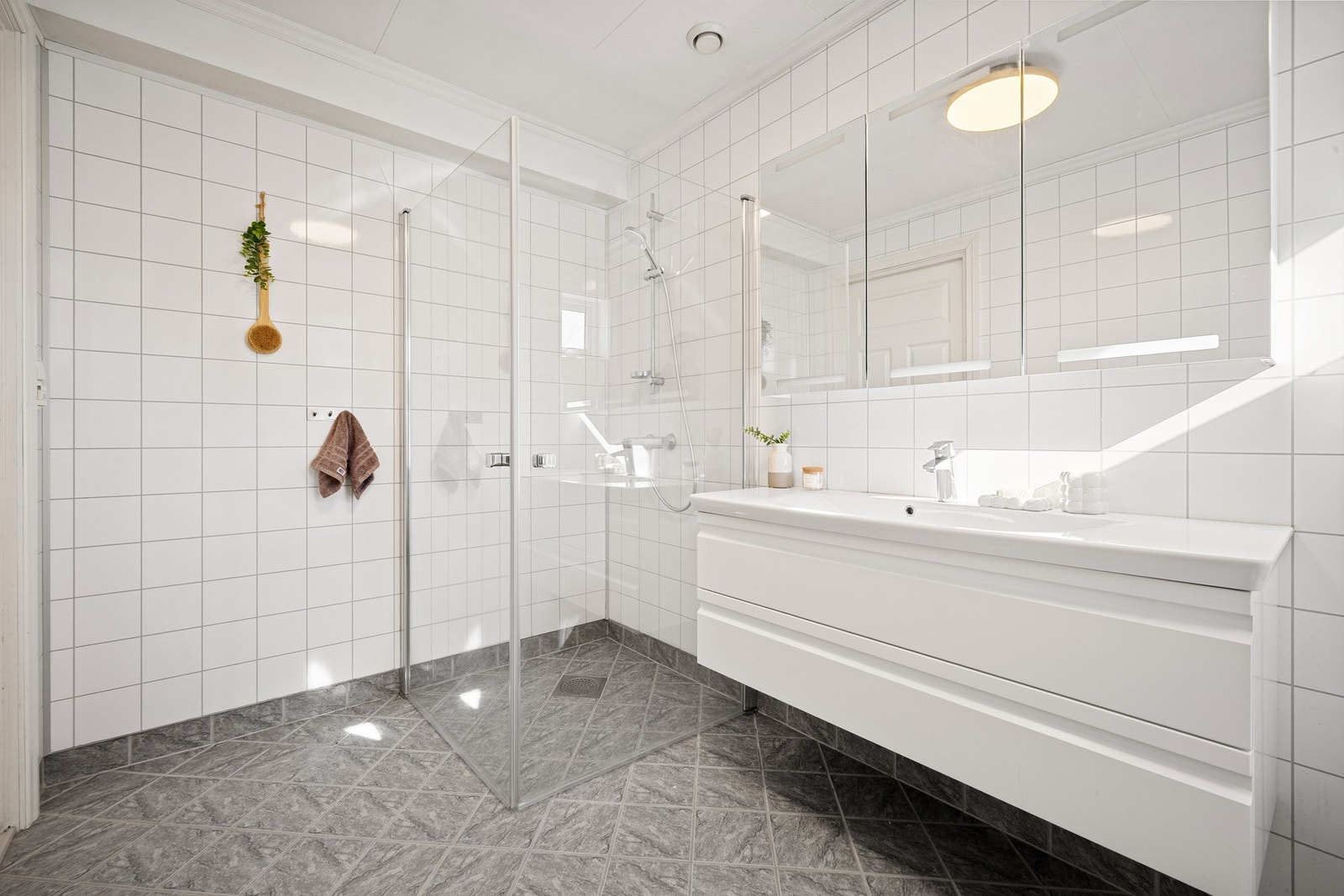Badet er på 6,3 kvm og har fliser på gulv med elektriske varmekabler og på veggene er det baderomsplater. Galleribilde