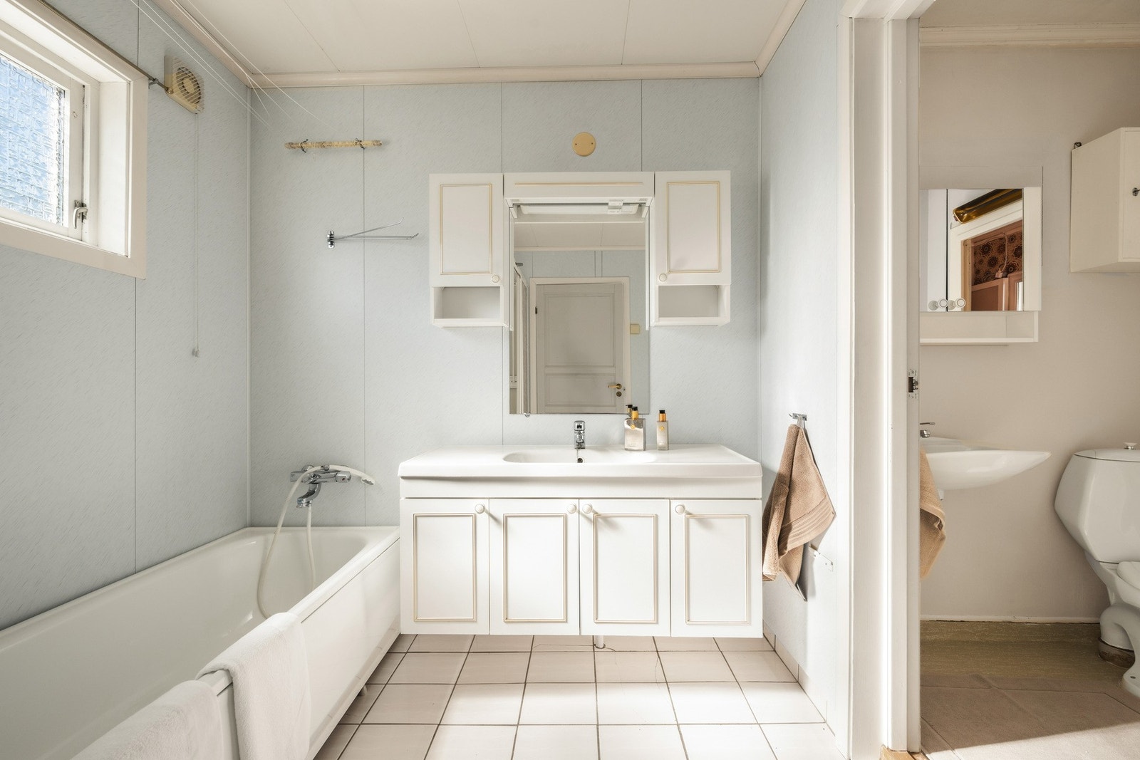 Badet har badekar, servant med oppbevaring og speilskap, samt et tilstøtende toalettrom. Galleribilde