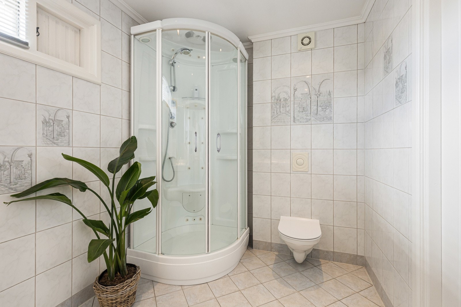 Badet har rikelig oppbevaringsplass med underskap, skuffer og høyskap, speil med integrert lys, samt servant, toalett og dusjkabinett med steam- og massasjefunksjon. Galleribilde