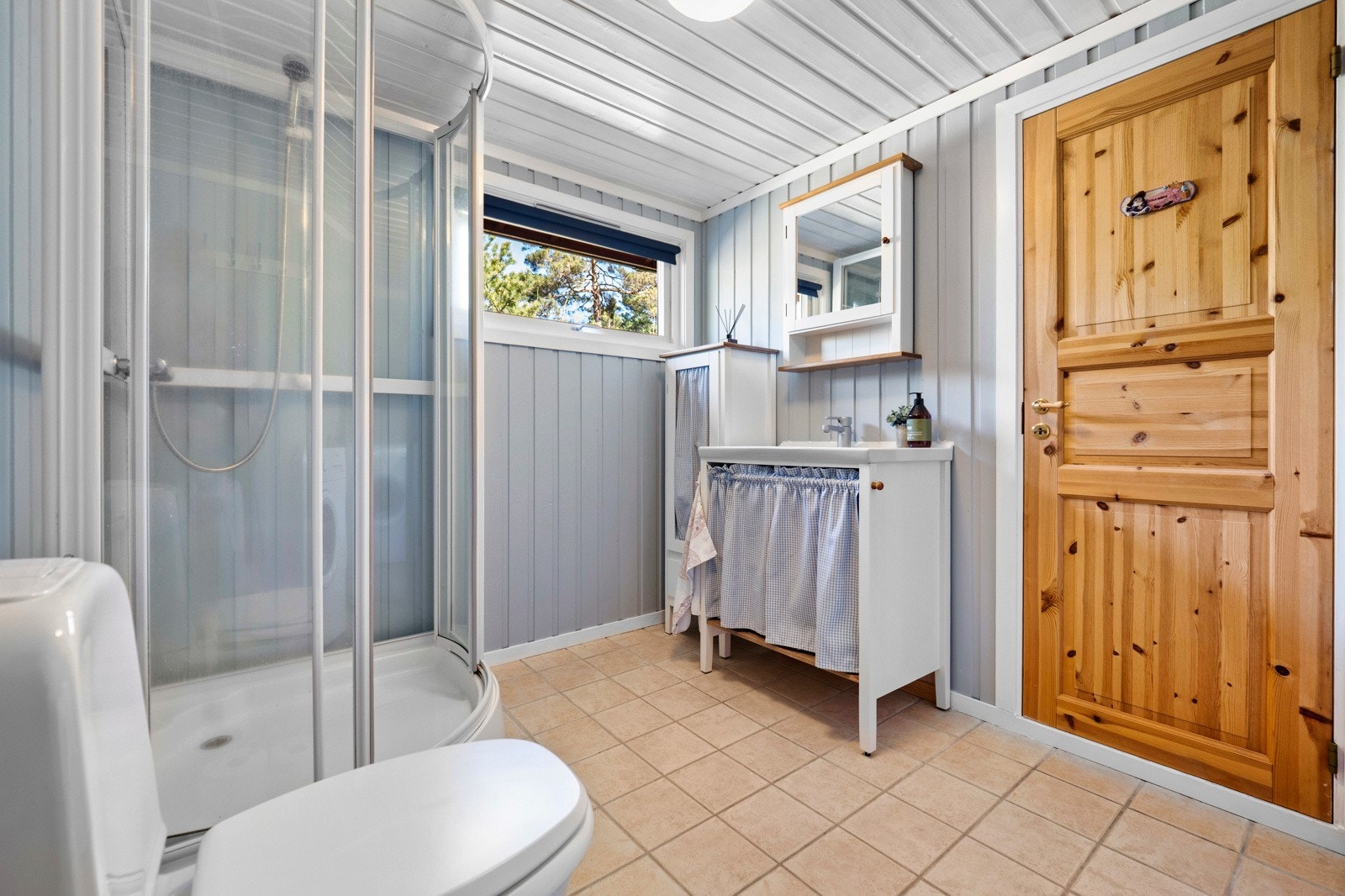 Badet er flislagt med varme i gulvet. Vegger og himling med trepanel. Galleribilde