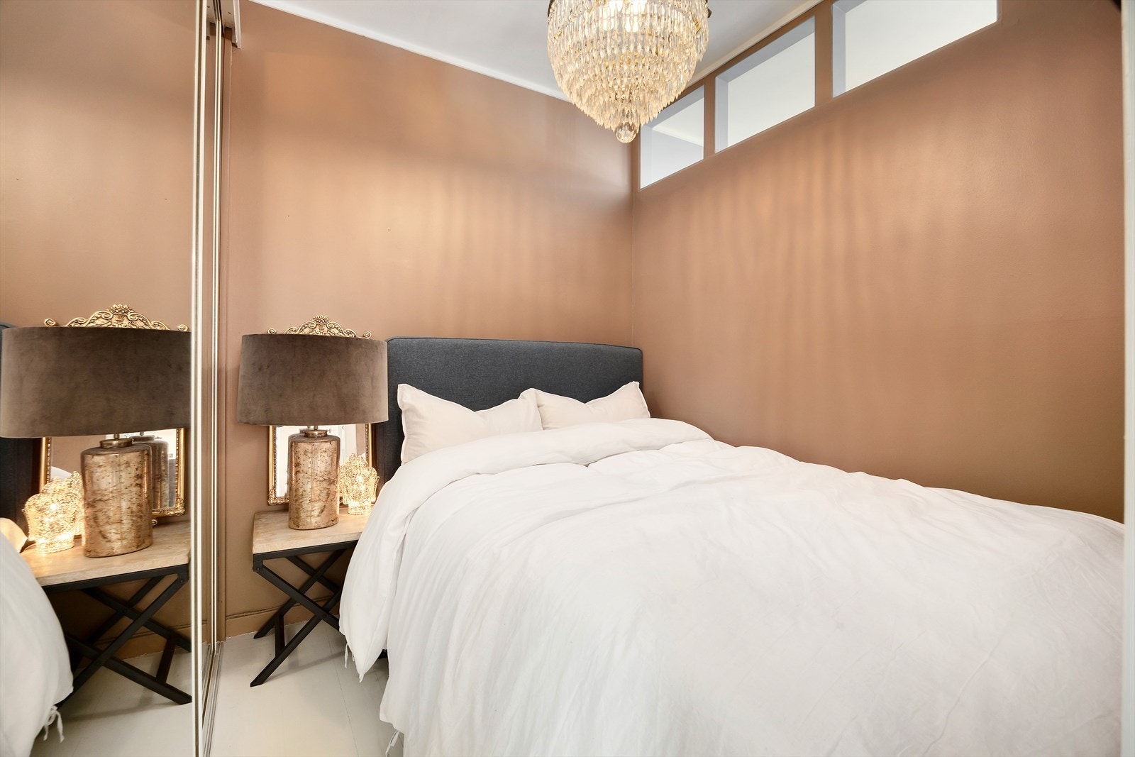 Skjermet sovealkove med plass til dobbeltseng og nattbord. Det er montert en stor skyvedørsgarderobe med speilfronter langs veggen, som ivaretar oppbevaringsbehovet på en praktisk og plassbesparende måte. Galleribilde