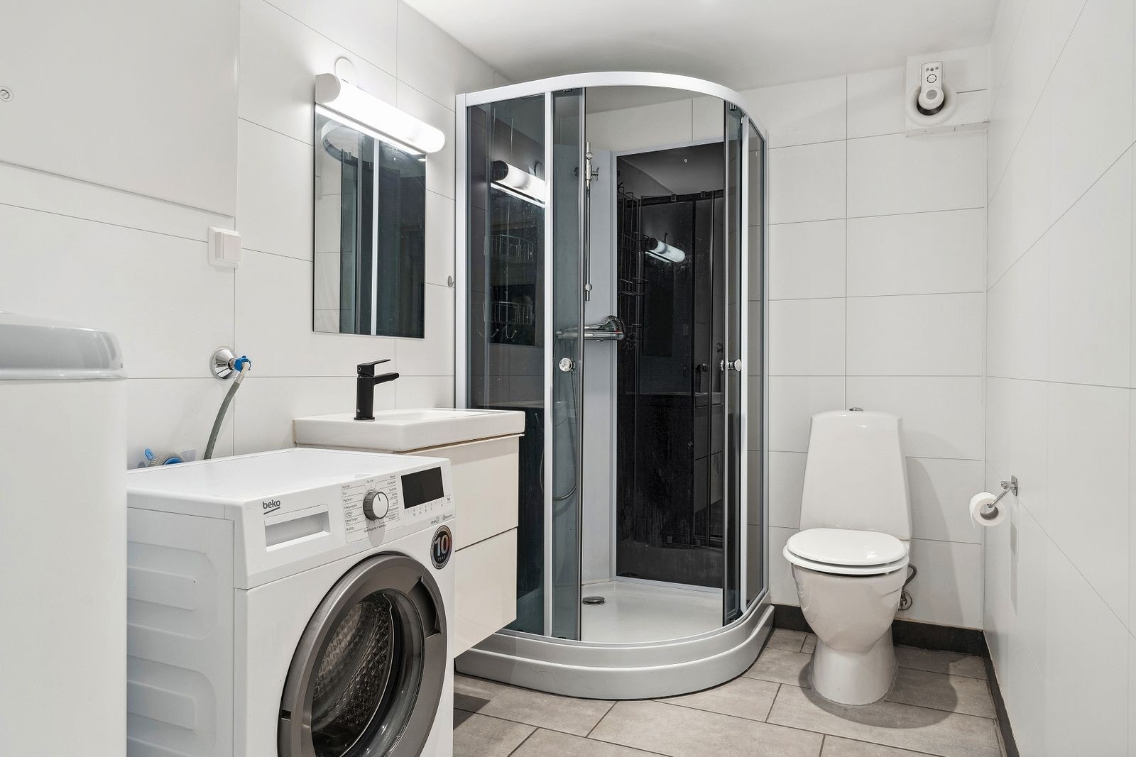 Badet i kjelleren er innredet med dusjkabinett, toalett og innredning med heldekkende servant og underskap - varmekabler i gulv Galleribilde