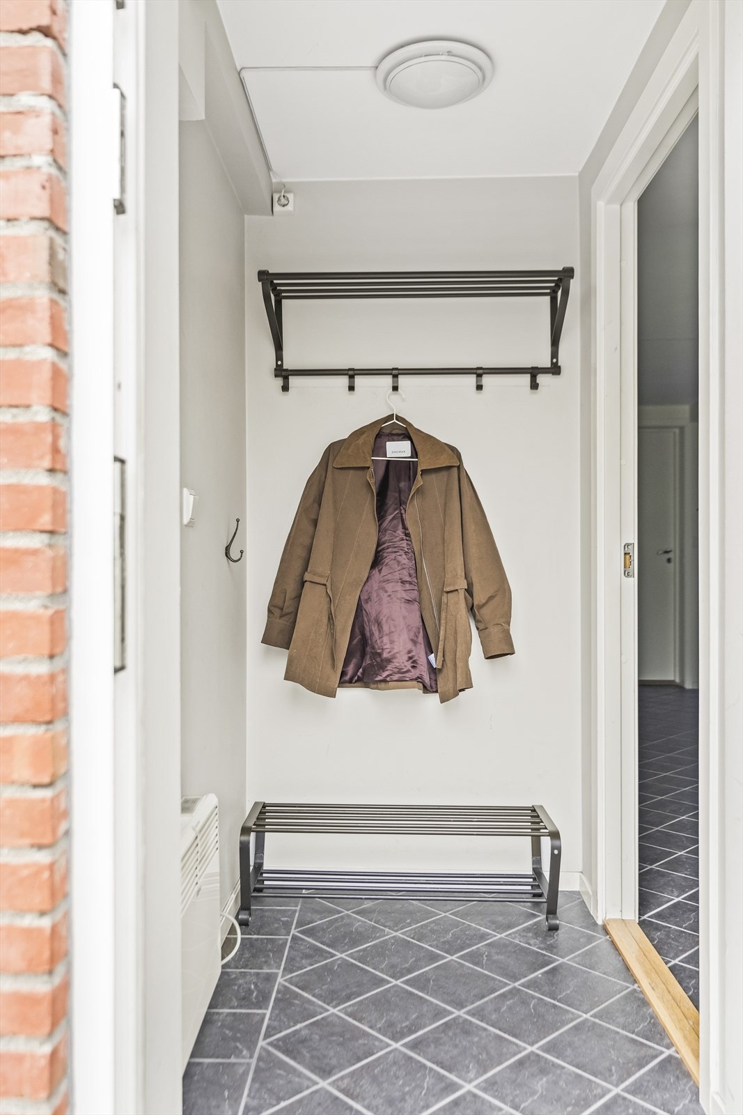 Entré med praktiske fliser på gulvet og plass til oppheng av jakker og oppbevaring av sko. Galleribilde