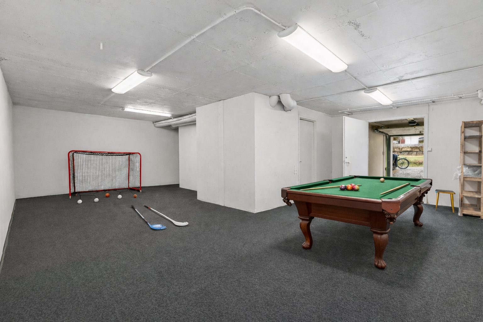 Dette rommet gir unike bruksmuligheter - enten man ønsker treningsrom, aktivitetsrom for barna eller sosiale soner med for eksempel biljardbord, bordtennis eller lignende - Ai-generert. Galleribilde