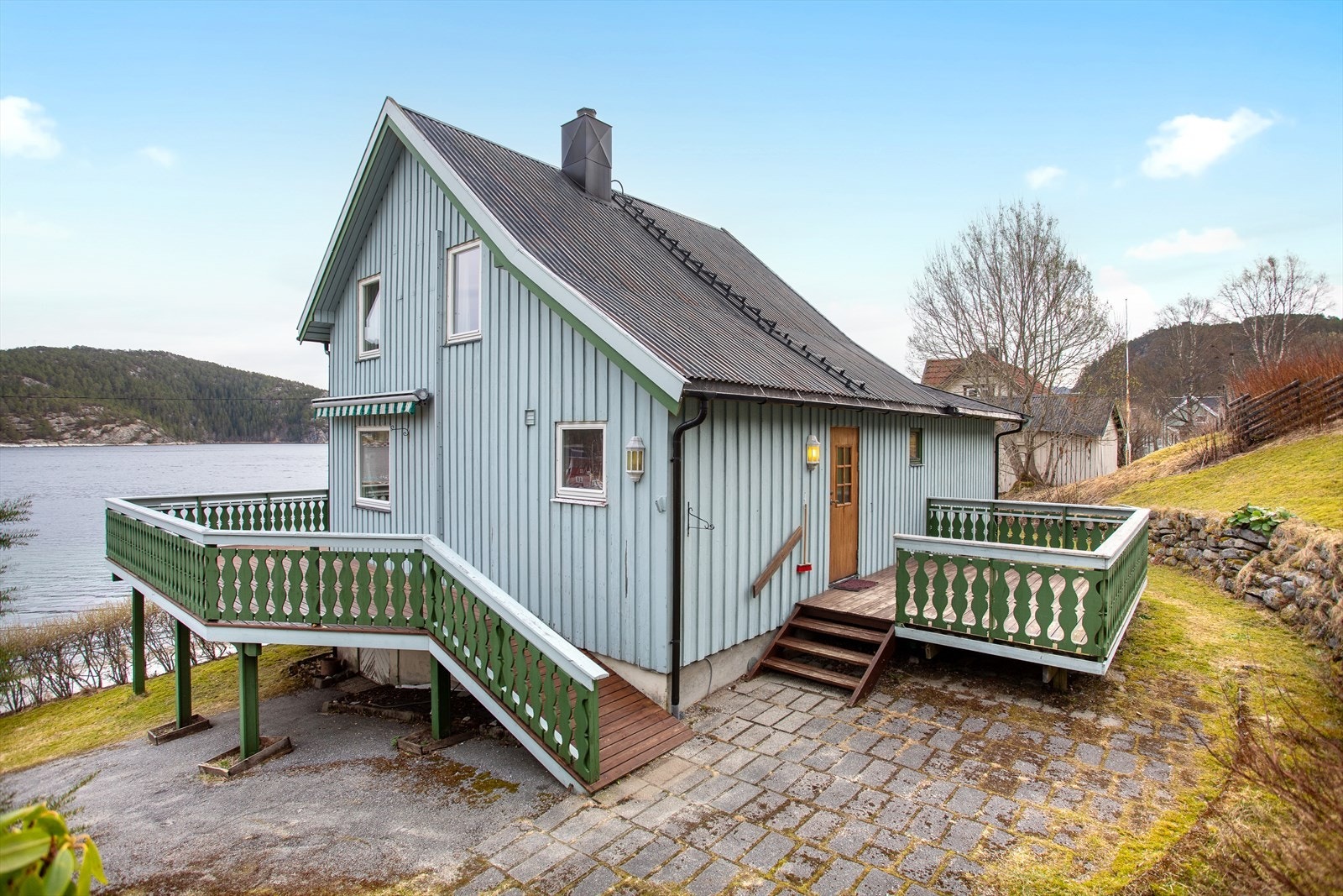Enebolig med veranda ved inngangspartiet og på fremsiden av boligen Galleribilde
