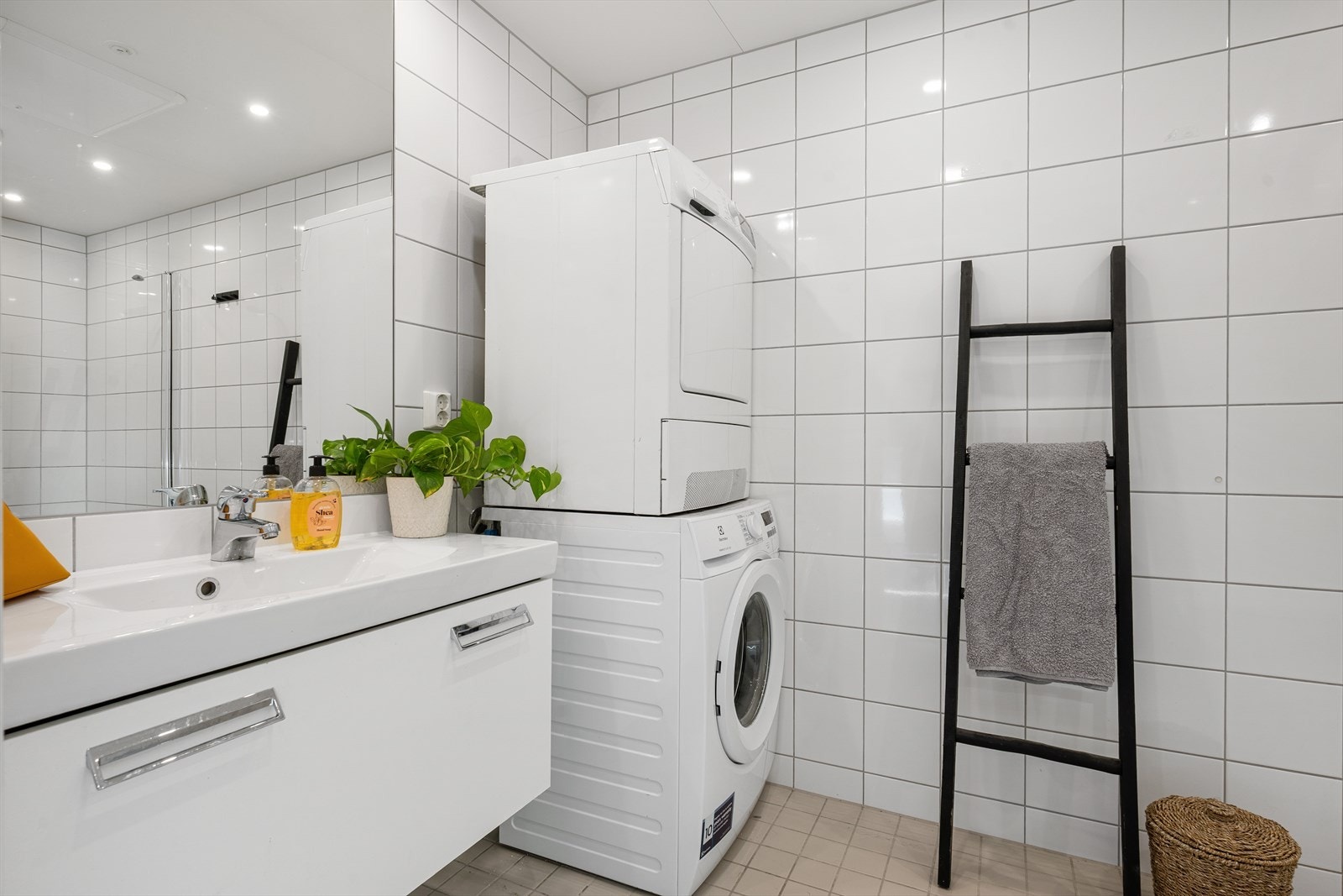 Badet fremstår som klassisk og tidløst, med flislagte overflater som gir et stilrent og lettstelt uttrykk. Rommet er godt utnyttet med en praktisk planløsning, servantinnredning med oppbevaring og speil som gir gode bruksegenskaper i hverdagen. Galleribilde