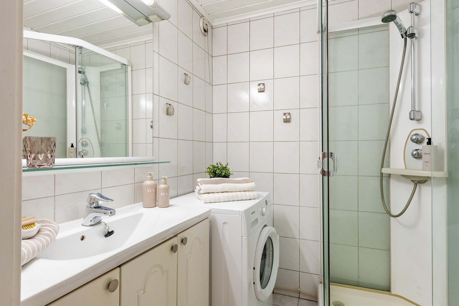 Flislagt bad av god størrelse utstyrt med dusjkabinett, servantinnredning og wc. Galleribilde