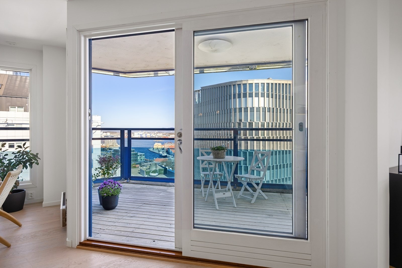 Balkongen er delvis under tak og har terrassebord på gulvet. Rekkverket i aluminium og glass er 123 cm høyt. Galleribilde