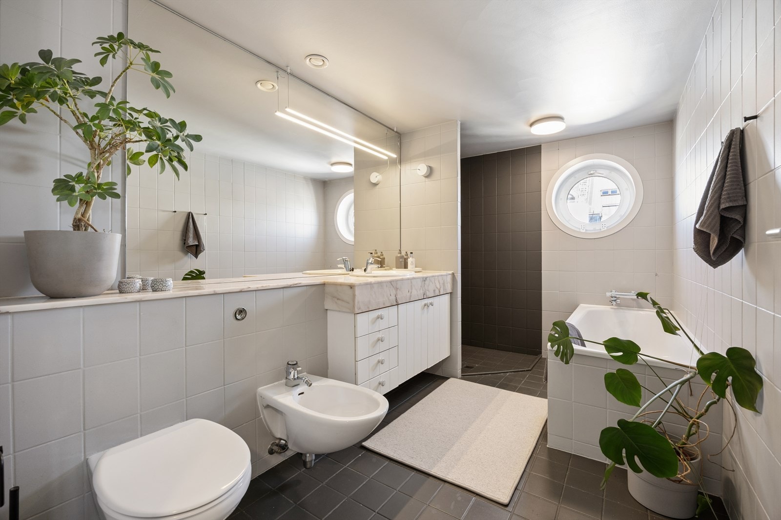 Hovedbadet er fra byggeåret og er utstyrt med badekar, dusjhjørne, vegghengt toalett, bide og elektriske varmekabler i gulvet. Galleribilde