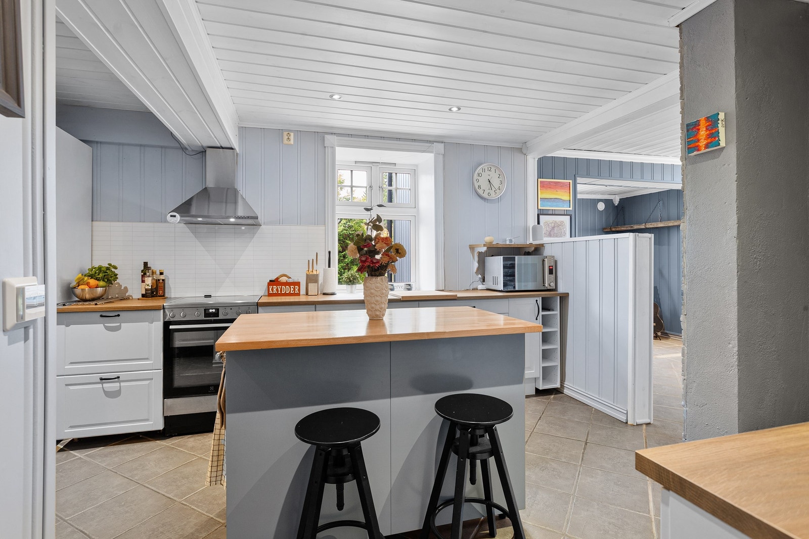 Innredet med komfyr, oppvaskmaskin og kjøl/frys, ventilator på vegg over komfyr Galleribilde