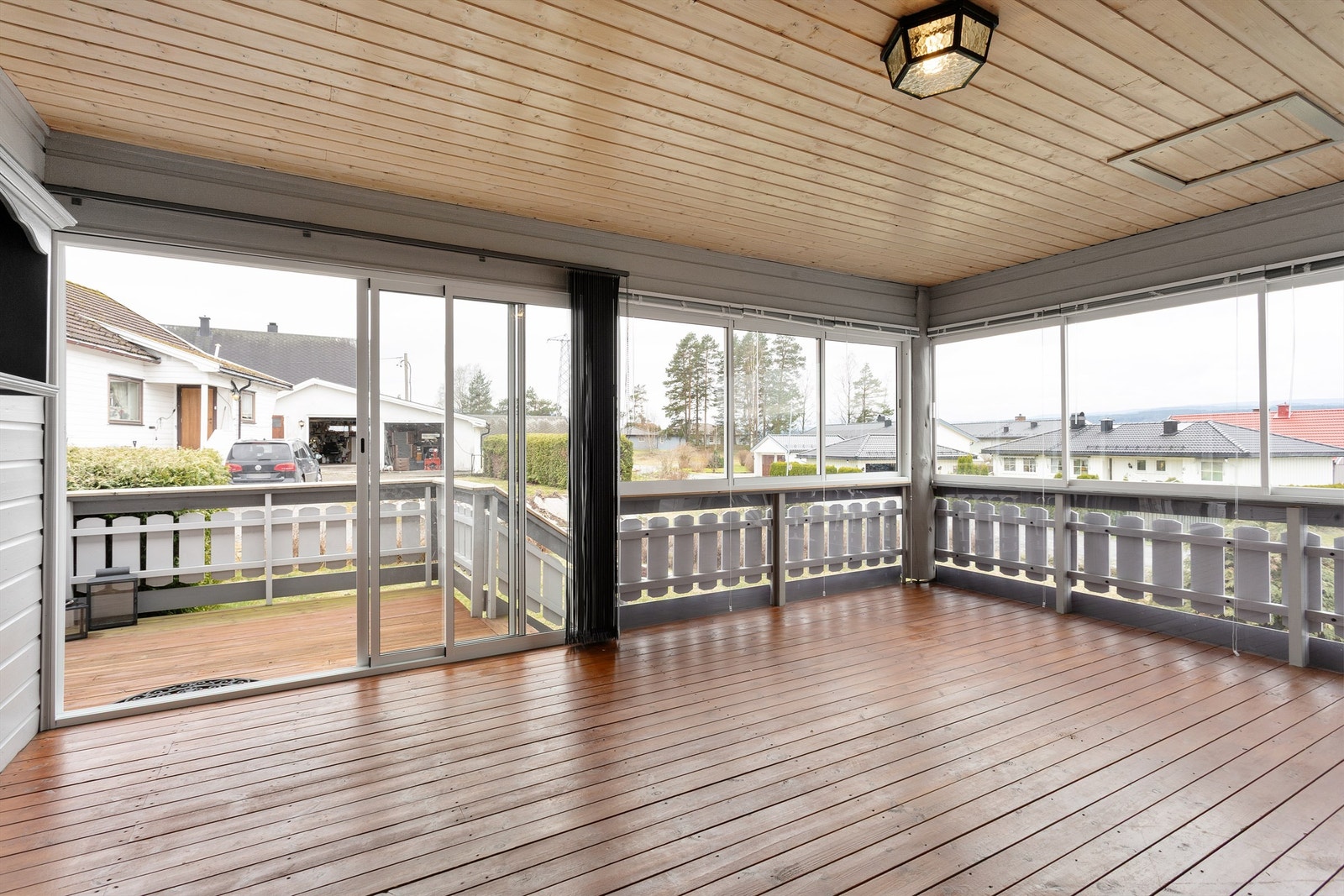 Romslig innglasset veranda med skyvedør ut til terrasse Galleribilde