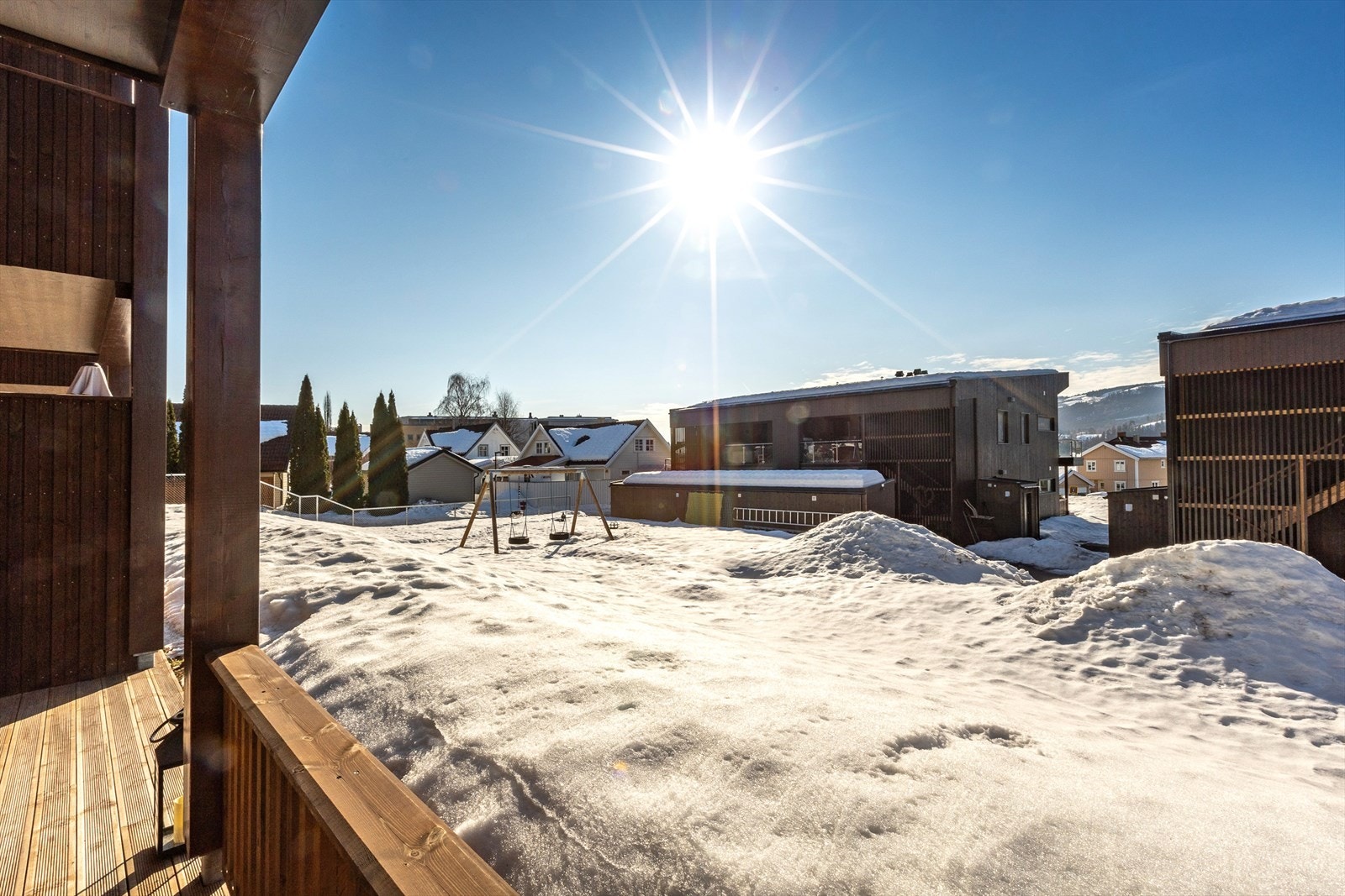 Fra den vestvendte terrassen ser man ut over sameiets fellesarealer med lekeplass. Galleribilde