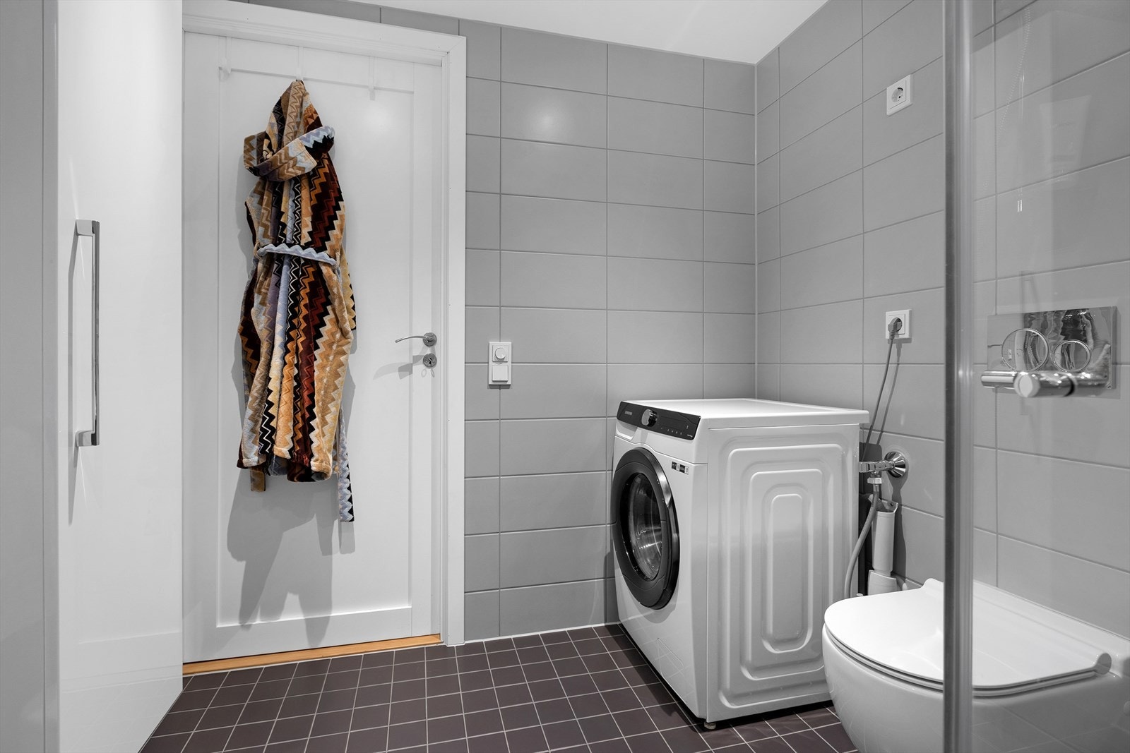 Badet er en prefabrikkert kabin med flislagte overflater og opplegg for vaskemaskin. Galleribilde