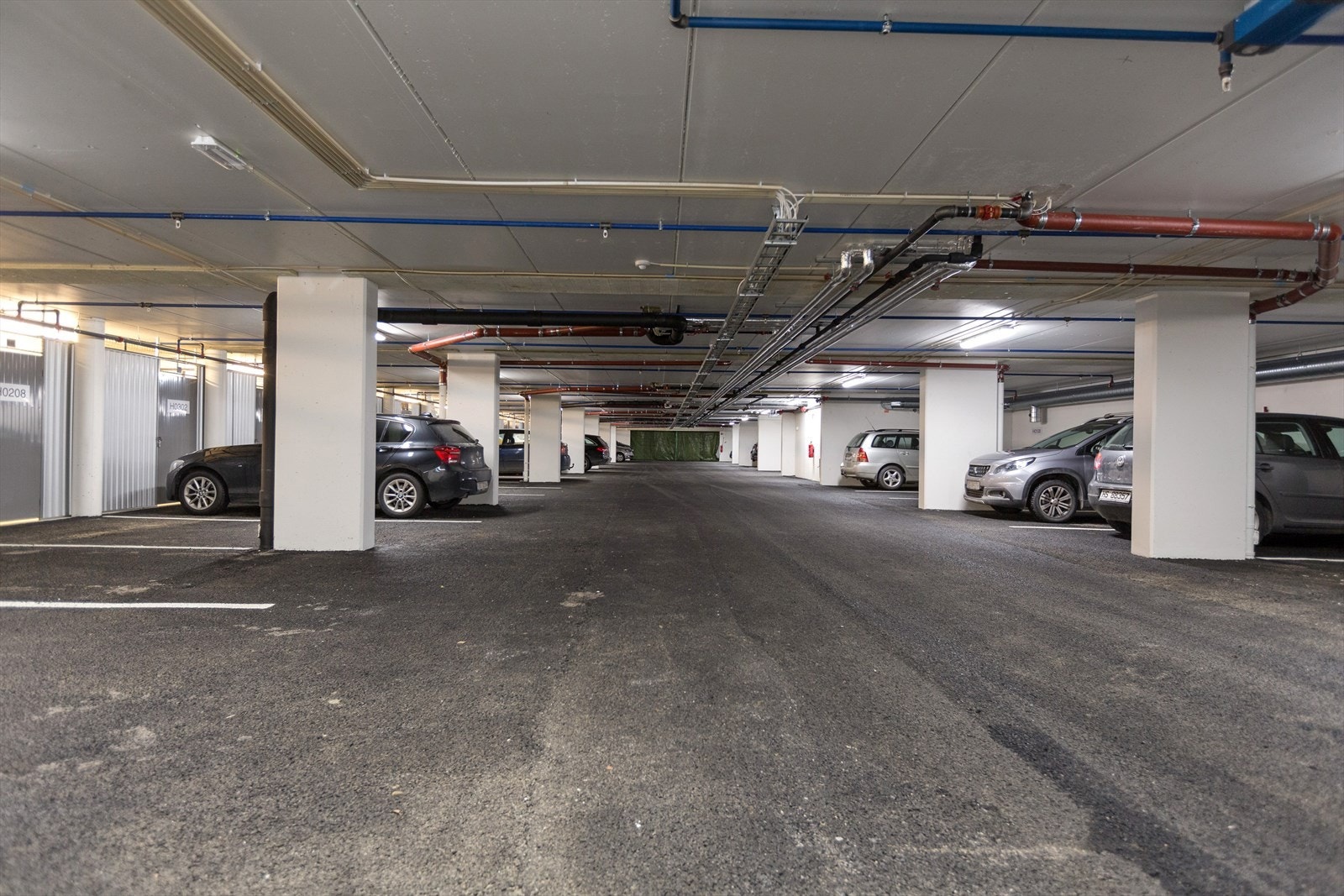 Leiligheten disponerer en fast parkeringsplass med elbillader (som leies) i felles garasjekjeller. Herfra er det enkel adkomst via heis eller trapperom. Galleribilde