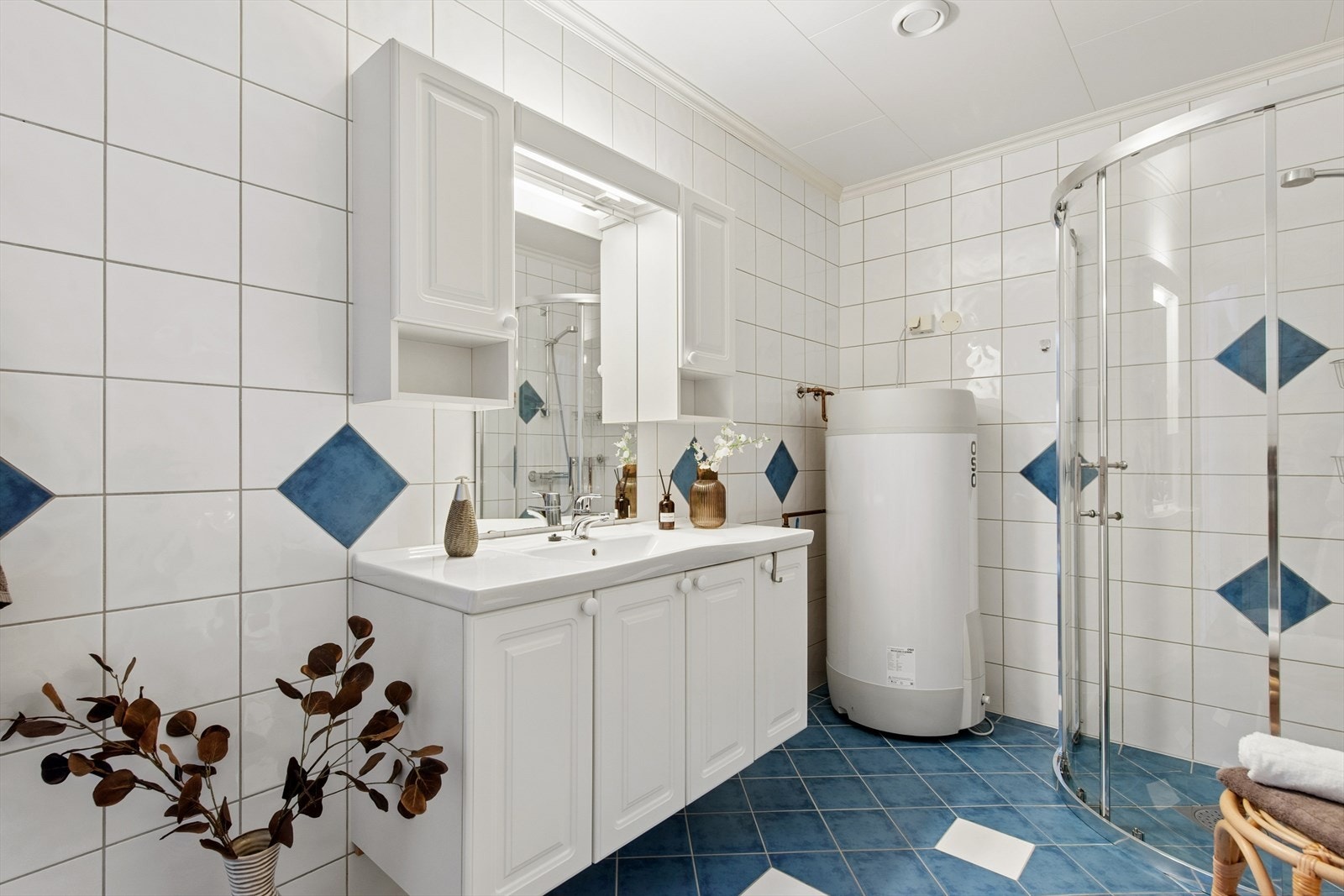 Badet er flislagt elektriske varmekabler i gulvet for økt komfort. Her er også opplegg for vaskemaskin. Galleribilde