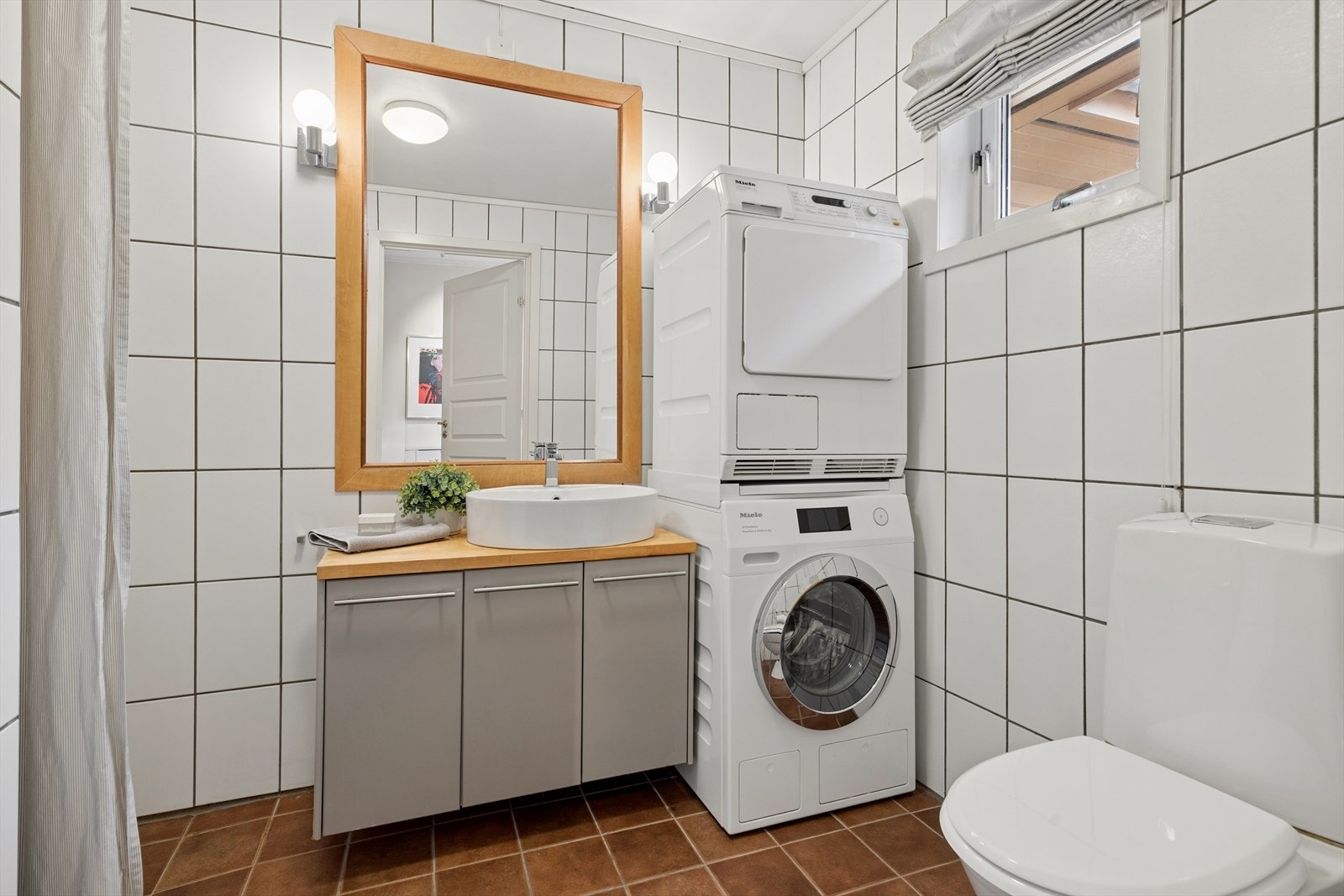 Badet i første etasje ble modernisert med egeninnsats i 2009 og er tidløst innredet med flis på gulv og vegger. Badet er ellers utstyrt med dusjnisje, toalett og baderomsinnredning med servant. I tillegg har man opplegg for vaskemaskin. Galleribilde