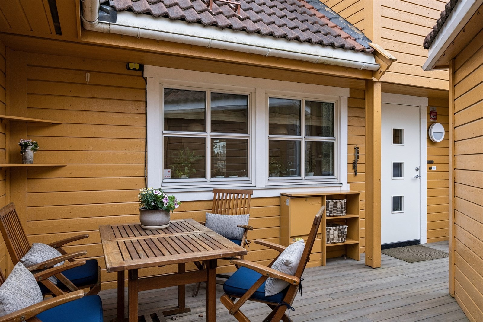 Inngangspartiet har en romslig terrasse på 20 kvm med god plass til sittegruppe og grill. Terrassen fikk nye terrassebord i 2024. Galleribilde