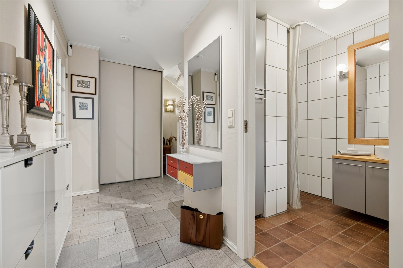 Man ønskes velkommen inn i en lys og innbydende gang som er praktisk innredet med grå fliser på gulvet fra 2016. I gulvet har man også varmekabler for ekstra komfort. Galleribilde