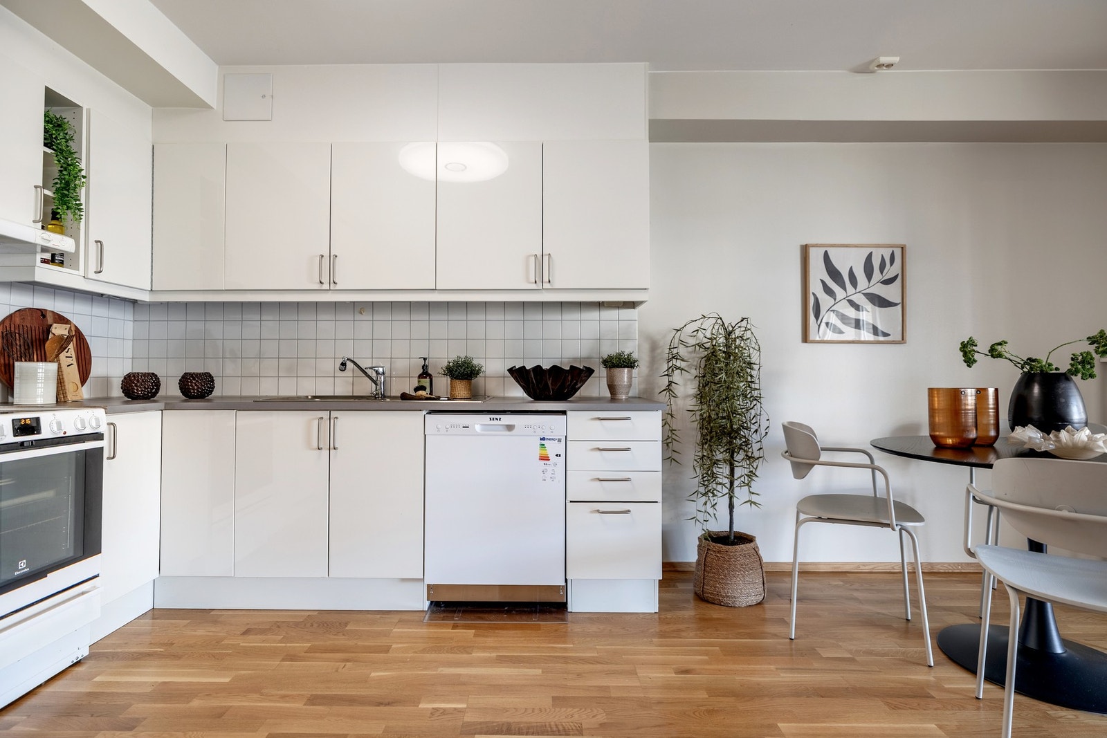 Kjøkkenet har en pen innredning med hvite, glatte fronter og laminerte benkeplater med kum. Det er rikelig med oppbevaringsplass i både skuffer og skap. Galleribilde