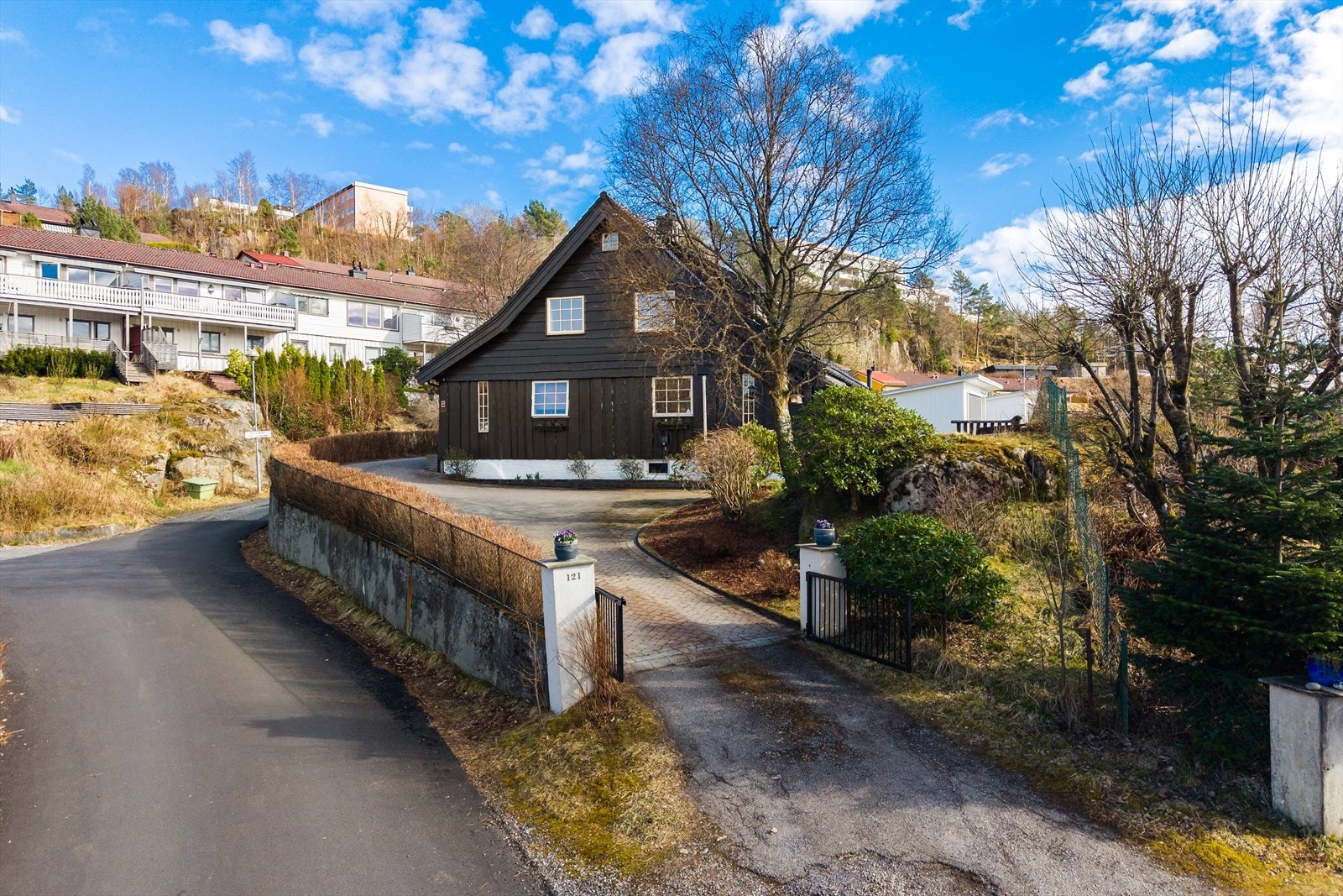 Boligen har god plass til parkering på egen tomt, og en herskapelig innkjørsel innrammet med hekk samt egen port. Galleribilde