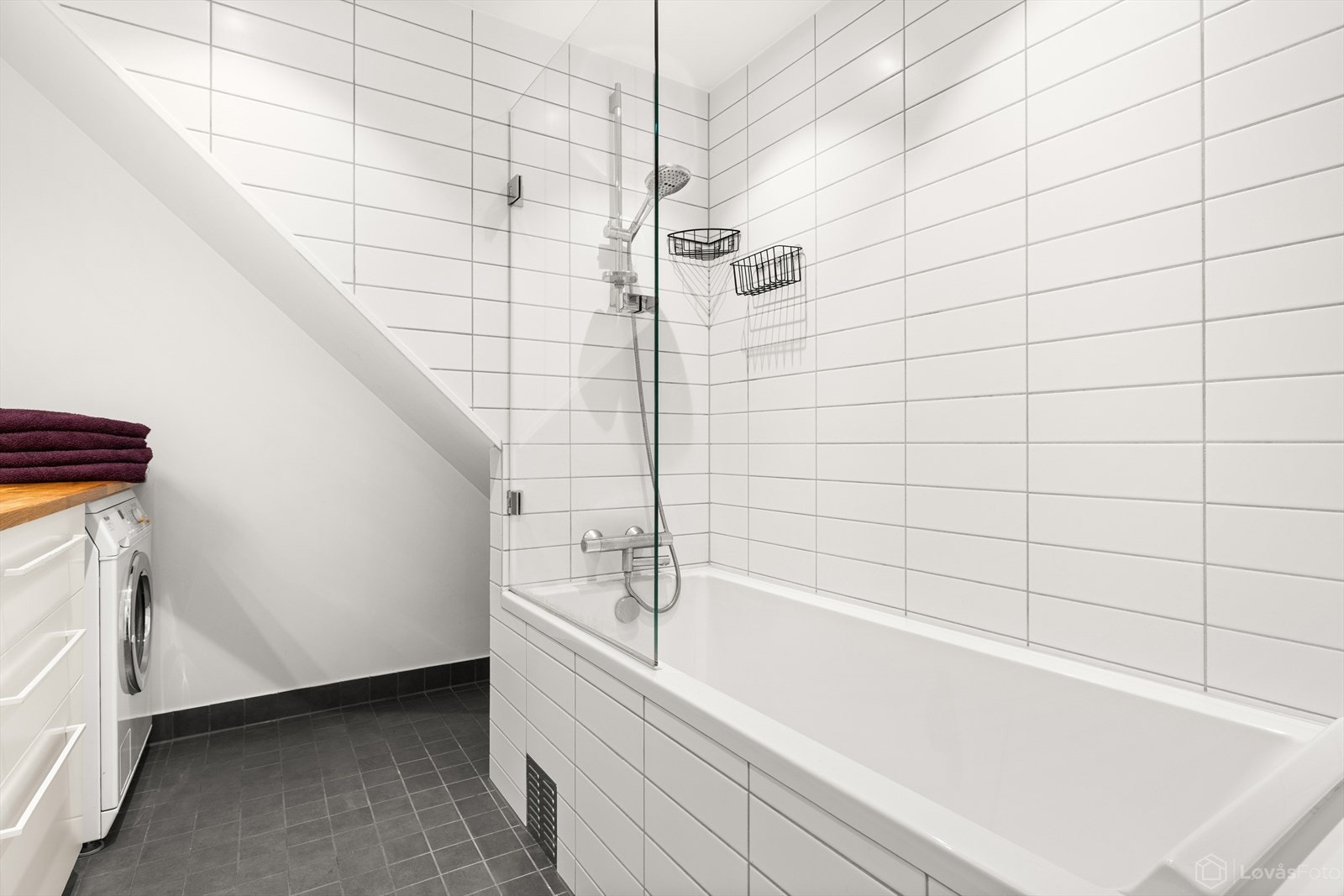 Badet er innredet med badekar med dusjløsning, servant med overspeil, benkeplate og underskap. Her er det også opplegg for vaskemaskin. Galleribilde