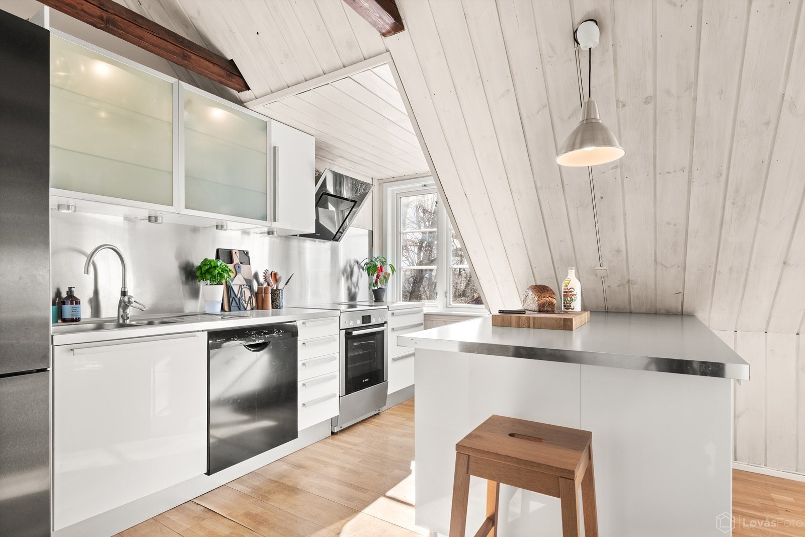 Innredningen er fra IKEA og består av hvite, glatte fronter, laminat benkeplate og nedfelt oppvaskkum. Galleribilde