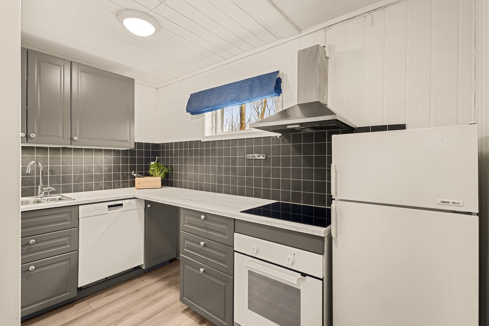 Kjøkkenet har IKEA innredning med profilerte fronter og laminert benkeplate Galleribilde
