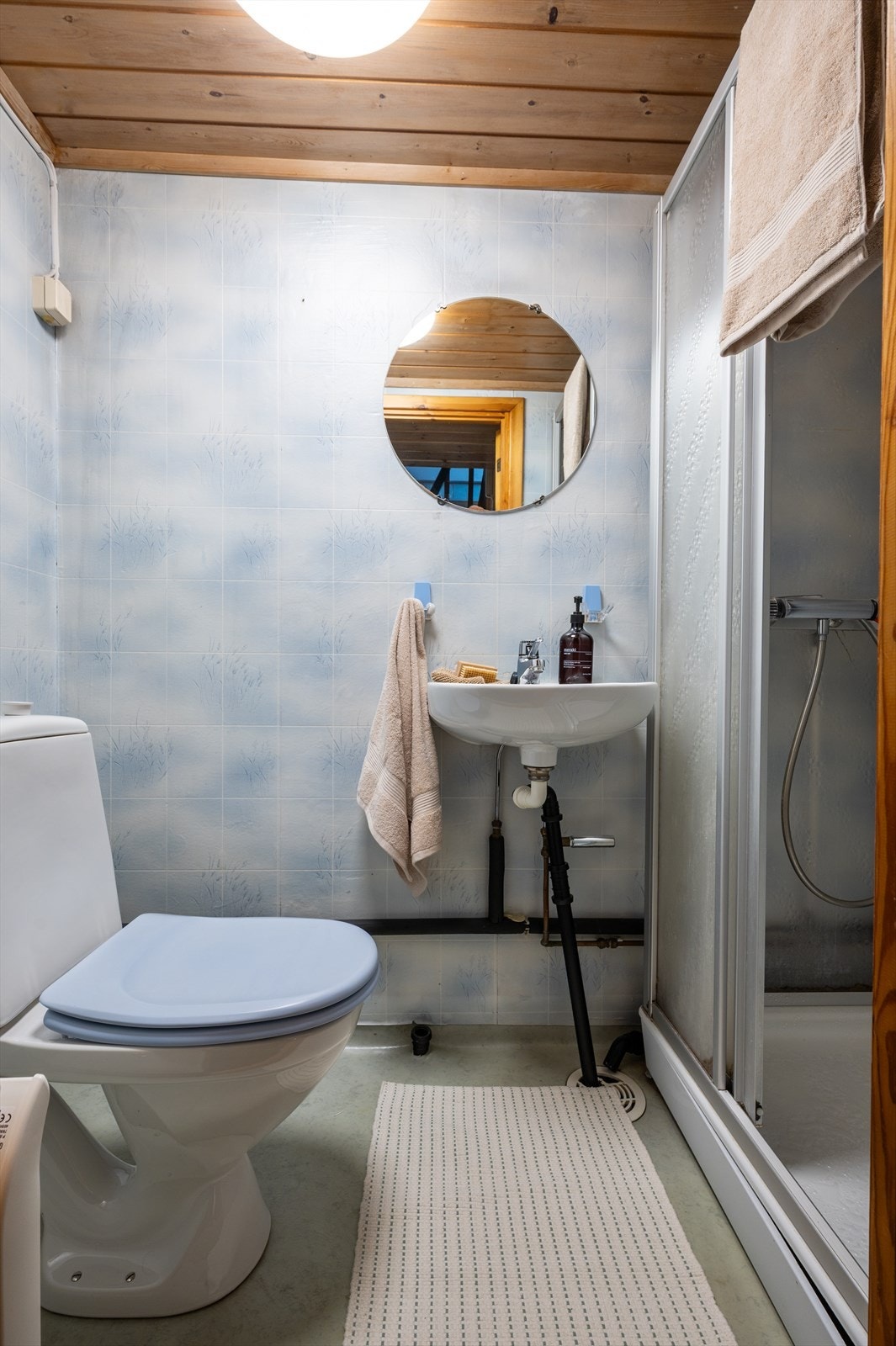 Badet i kjelleren er utstyrt med gulvstående toalett, dusjkabinett og vegghengt servant. Galleribilde